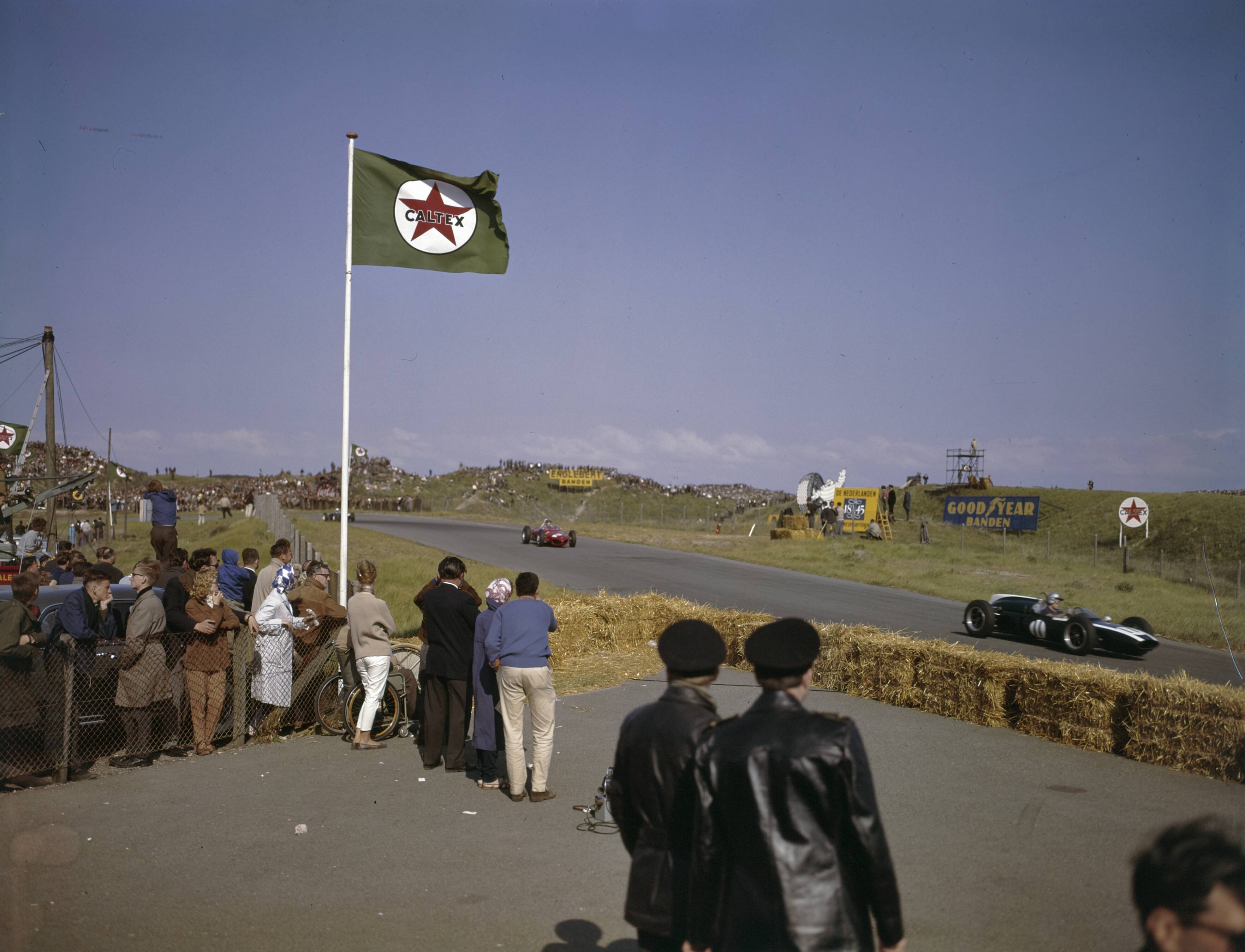 Fotocollectie Anefo — [Grand Prix Zandvoort 1961. Rechts raceauto met nr. 11 (Bruce McLaren)] — Foto: Fotograaf Onbekend / Anefo. Licentie: Set B: Rechtenvrij / Publiek Domein. Bron: Nationaal Archief. http://hdl.handle.net/10648/ad8cd3e4-d0b4-102d-bcf8-003048976d84