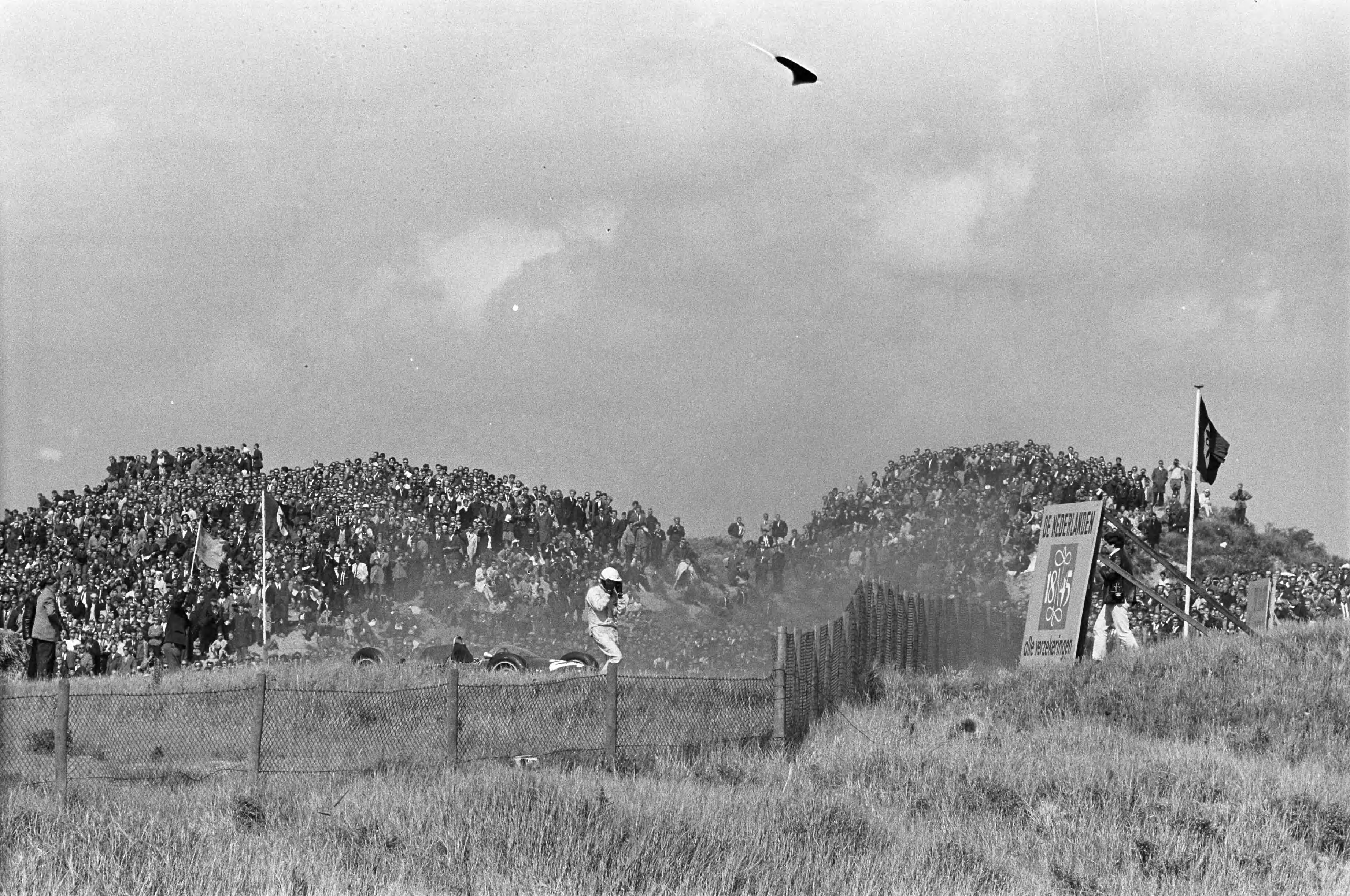 Fotocollectie Anefo — Grand Prix te Zandvoort. Phil Hill remde zijn wagen uit daar hij bang was dat deze in brand vloog — Foto: Pot, Harry / Anefo. Licentie: Set B: Rechtenvrij / Publiek Domein. Bron: Nationaal Archief. http://hdl.handle.net/10648/aa3be5cc-d0b4-102d-bcf8-003048976d84
