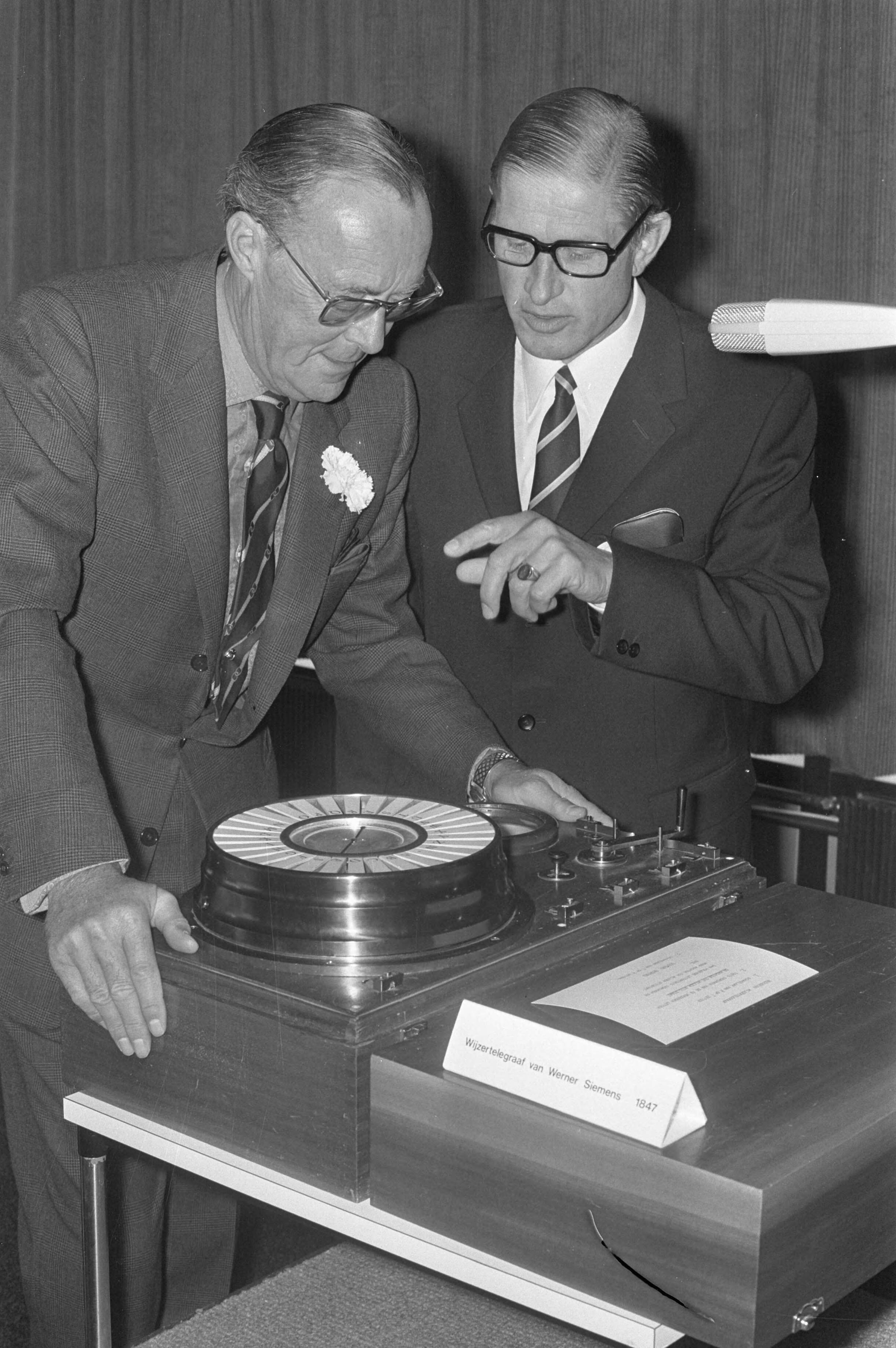 Fotocollectie Anefo — Prins Bernhard opent nieuw hoofdkantoor Siemens Nederland NV te Den Haag , prins Bernhard en drs. B. Henny bij oude wijzertelegraaf — Foto: Punt, W. / Anefo. Licentie: Set B: Rechtenvrij / Publiek Domein. Bron: Nationaal Archief. http://hdl.handle.net/10648/abf73a06-d0b4-102d-bcf8-003048976d84