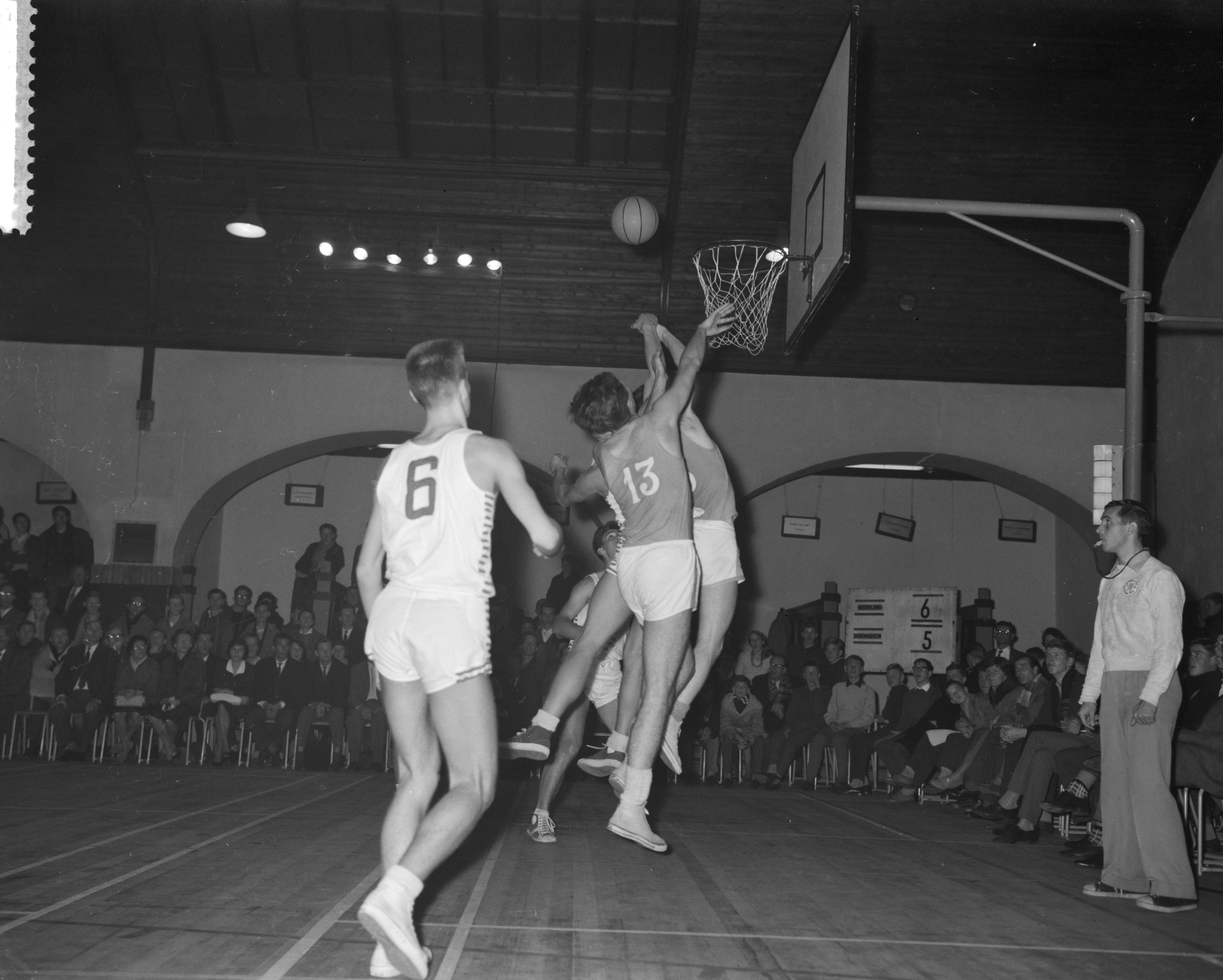 Fotocollectie Anefo — Basketbalwedstrijd Nederland tegen Denemarken in het Krelage Huis te Haarlem (70-54). Spelmoment onder de Deense basket — Foto: Rossem, Wim van / Anefo. Licentie: Set B: Rechtenvrij / Publiek Domein. Bron: Nationaal Archief. http://hdl.handle.net/10648/a9bd8416-d0b4-102d-bcf8-003048976d84