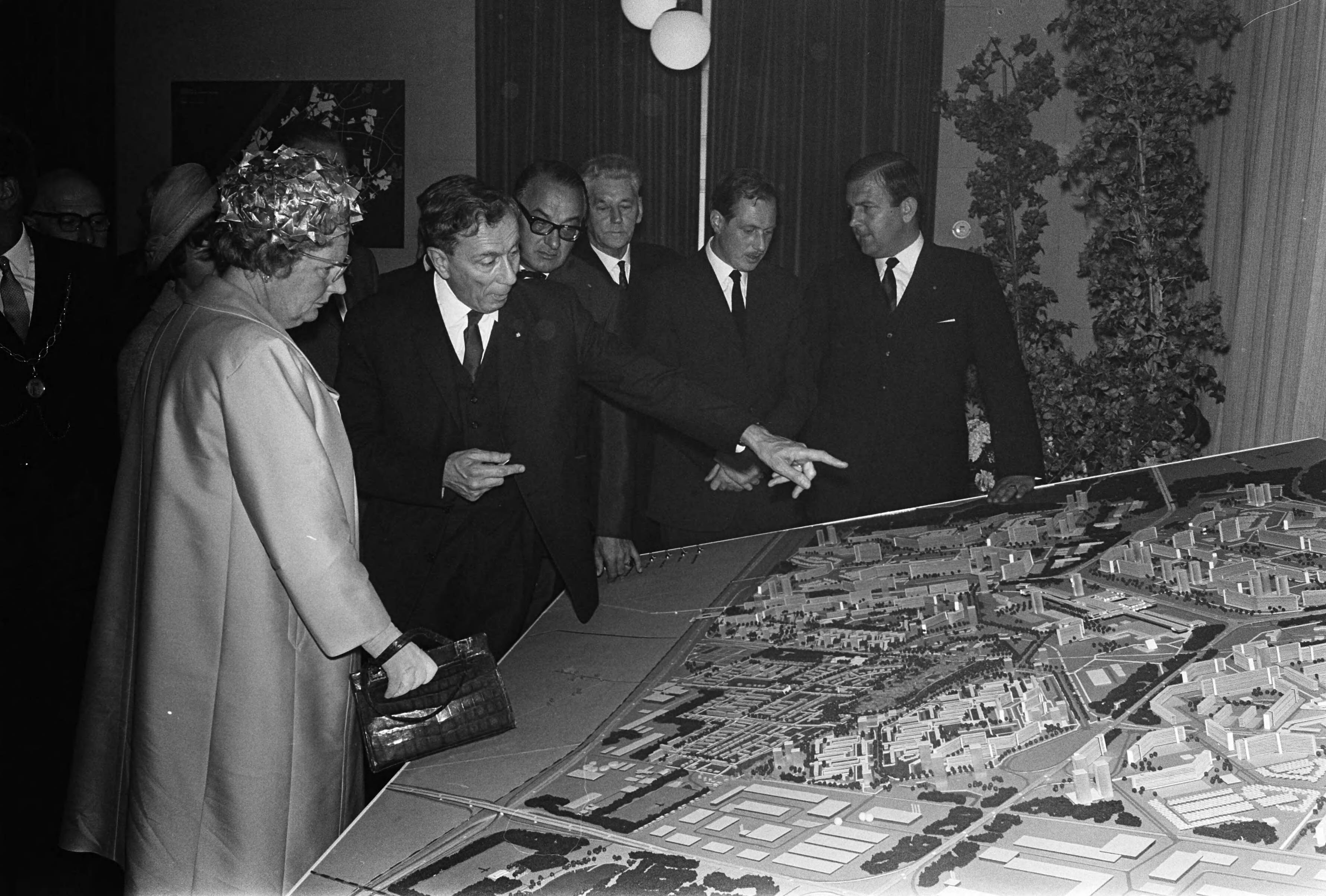 Koningin Juliana bezoekt enkele Zuid-Hollandse gemeenten — Koningin Juliana bezoekt enkele Zuid-Hollandse gemeenten. In Zoetermeer bekijkt de koningin een maquette en krijgt een toelichting van drs. A.G. van der Veen, directetur van de E.T.I. — Foto: Koch, Eric / Anefo. Licentie: Set B: Rechtenvrij / Publiek Domein. Bron: Nationaal Archief. http://hdl.handle.net/10648/aaaa2a14-d0b4-102d-bcf8-003048976d84