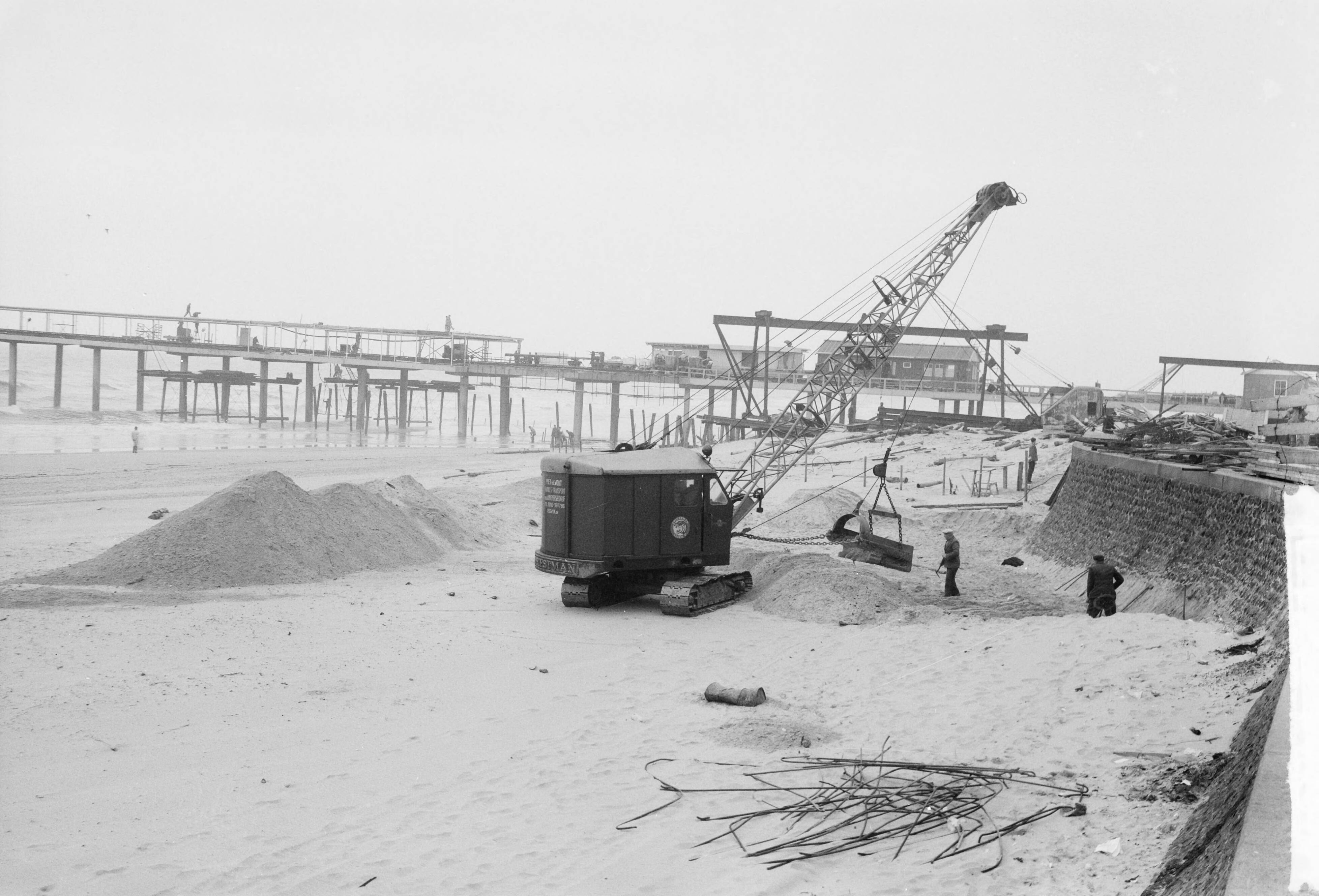 Fotocollectie Anefo — Egaliseren van het strand te Scheveningen voor het komend badseizoen — Foto: Behrens, Herbert F. / Anefo. Licentie: Set B: Rechtenvrij / Publiek Domein. Bron: Nationaal Archief. http://hdl.handle.net/10648/a9ccf1f8-d0b4-102d-bcf8-003048976d84