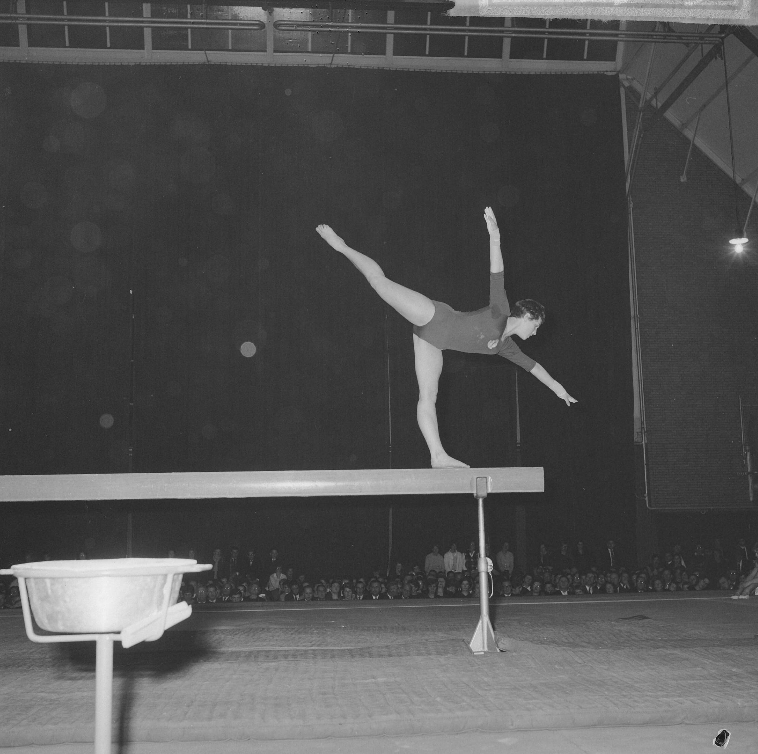 Fotocollectie Anefo — Turninterland Nederland-West-Duitsland in de Centrale Veilinghal te Aalsmeer. Jannie Vierstra op de evenwichtsbalk — Foto: Nijs, Jac. de / Anefo. Licentie: Set B: Rechtenvrij / Publiek Domein. Bron: Nationaal Archief. http://hdl.handle.net/10648/aa2001ea-d0b4-102d-bcf8-003048976d84