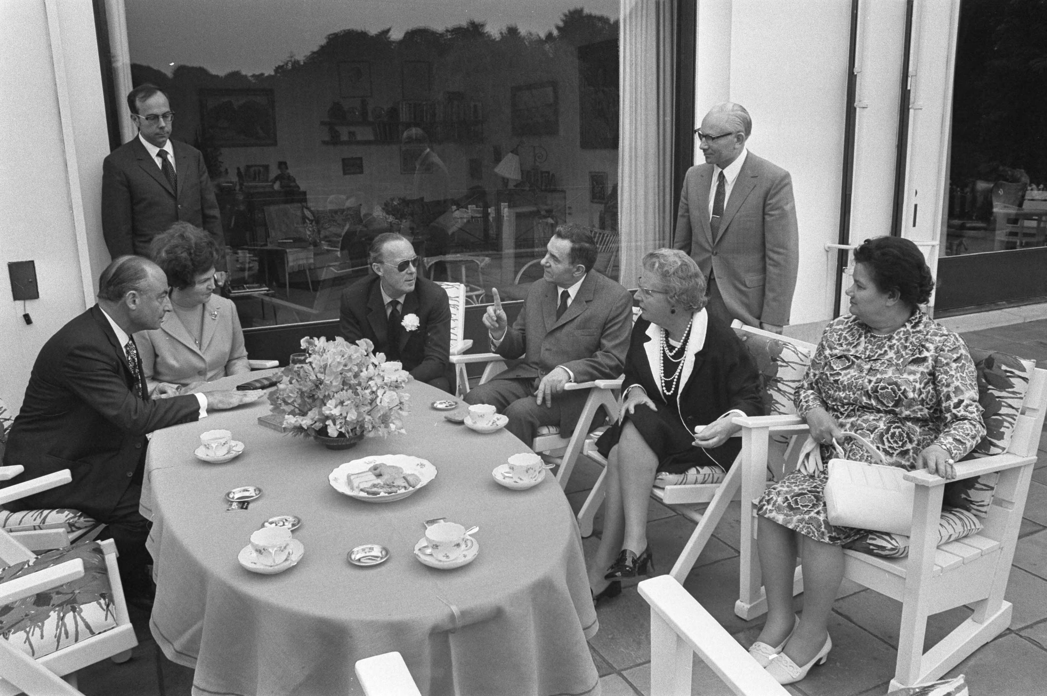 Koningin Juliana ontvangt Russische Minister van Buitenlandse Zaken, Gromyko, op Soestdijk — Aan tafel op het terras v.l.n.r. minister Schmelzer van Buitendse Zaken, een onbekende dame, prins Bernhard, minister Gromyko, koningin Juliana en mevrouw Gromyko, — Foto: Fotograaf Onbekend / Anefo. Licentie: Set B: Rechtenvrij / Publiek Domein. Bron: Nationaal Archief. http://hdl.handle.net/10648/abeee7ac-d0b4-102d-bcf8-003048976d84