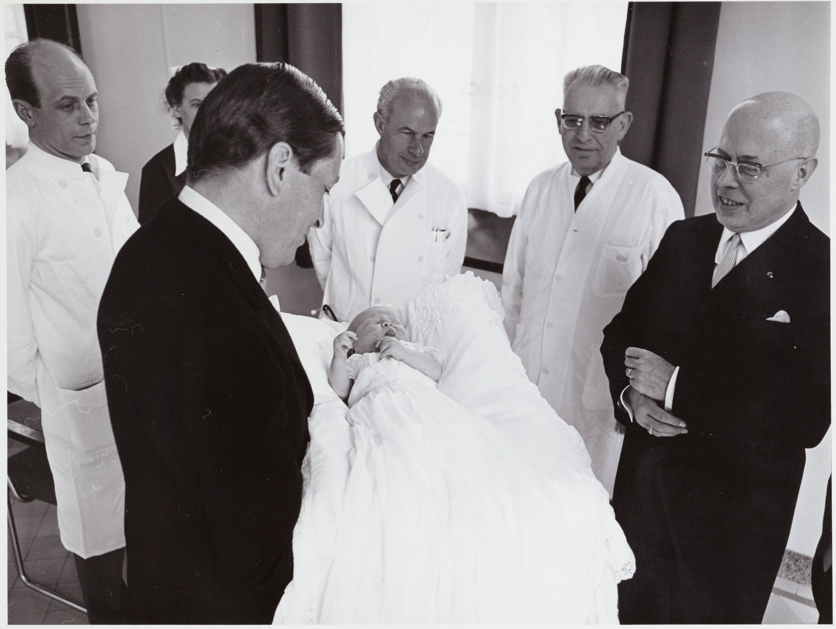 Fotocollectie RVD / Koninklijk Huis — Prins Claus toont de baby prins Willem-Alexander aan de doktoren in het Academisch Ziekenhuis Utrecht op 2 mei 1967 — Foto: Nationaal Foto Persbureau / RVD. Licentie: Set B: Rechtenvrij / Publiek Domein. Bron: Nationaal Archief. http://hdl.handle.net/10648/afaf31bc-d0b4-102d-bcf8-003048976d84
