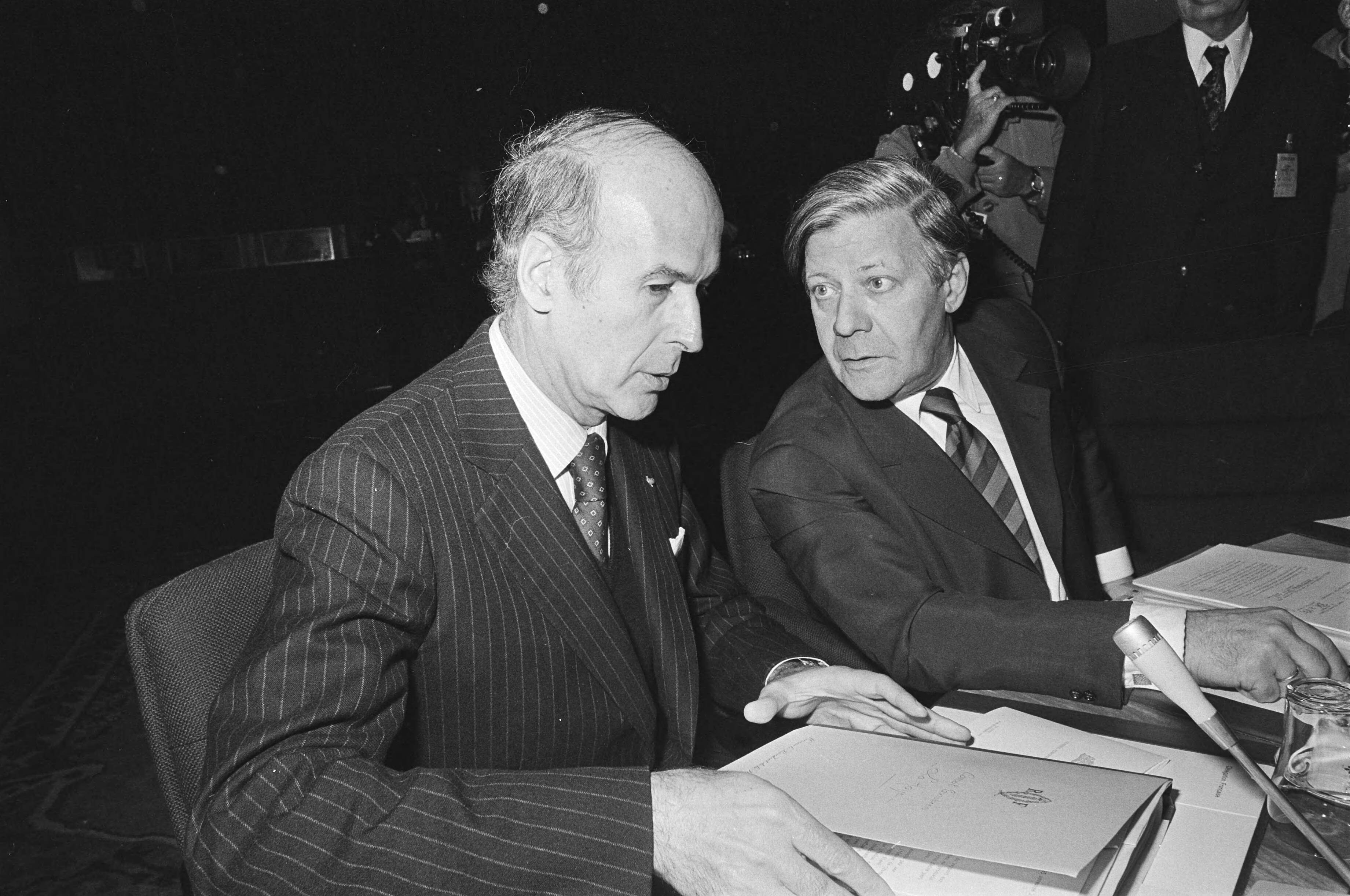 Fotocollectie Anefo — Bijeenkomst regeringsleiders EG in Den Haag ; links Giscard dEstaing en Schmidt — Foto: Peters, Hans / Anefo. Licentie: Set B: Rechtenvrij / Publiek Domein. Bron: Nationaal Archief. http://hdl.handle.net/10648/ac90f998-d0b4-102d-bcf8-003048976d84
