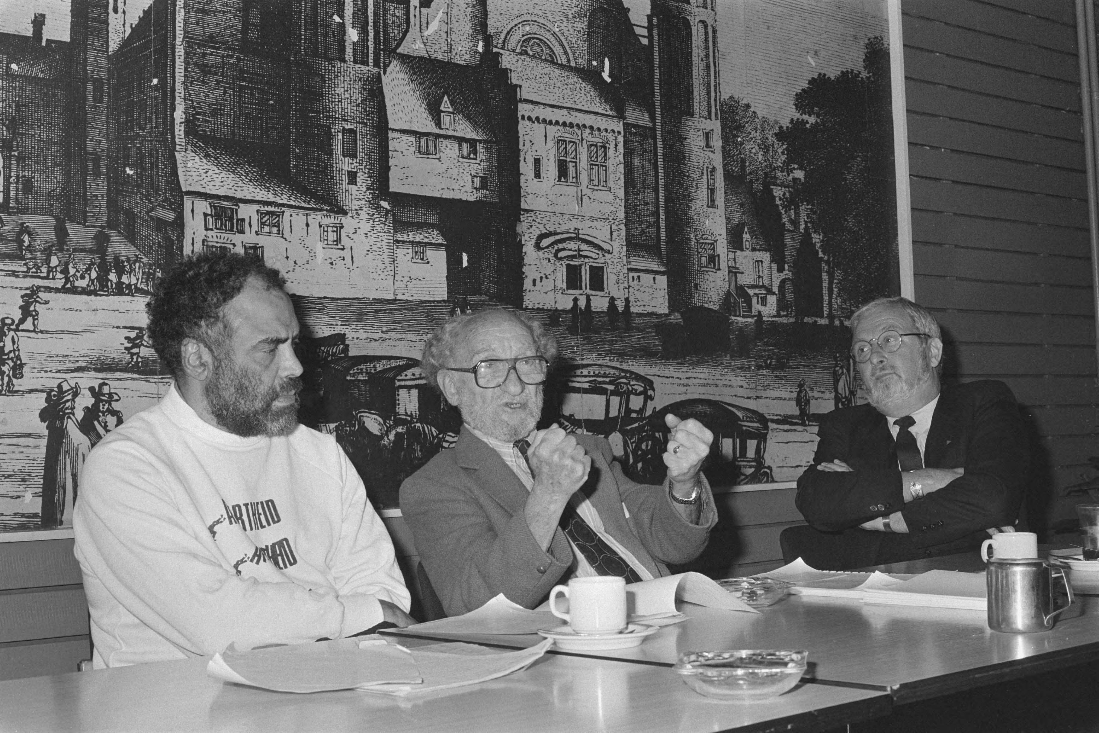 Fotocollectie Anefo — Persconferentie enkele schrijvers van "Apartheid Made in Europe" in Den Haag ; vlnr: du Plessis (coordinator BO Rubin, Roskam — Foto: Bogaerts, Rob / Anefo. Licentie: Set B: Rechtenvrij / Publiek Domein. Bron: Nationaal Archief. http://hdl.handle.net/10648/ad5982be-d0b4-102d-bcf8-003048976d84