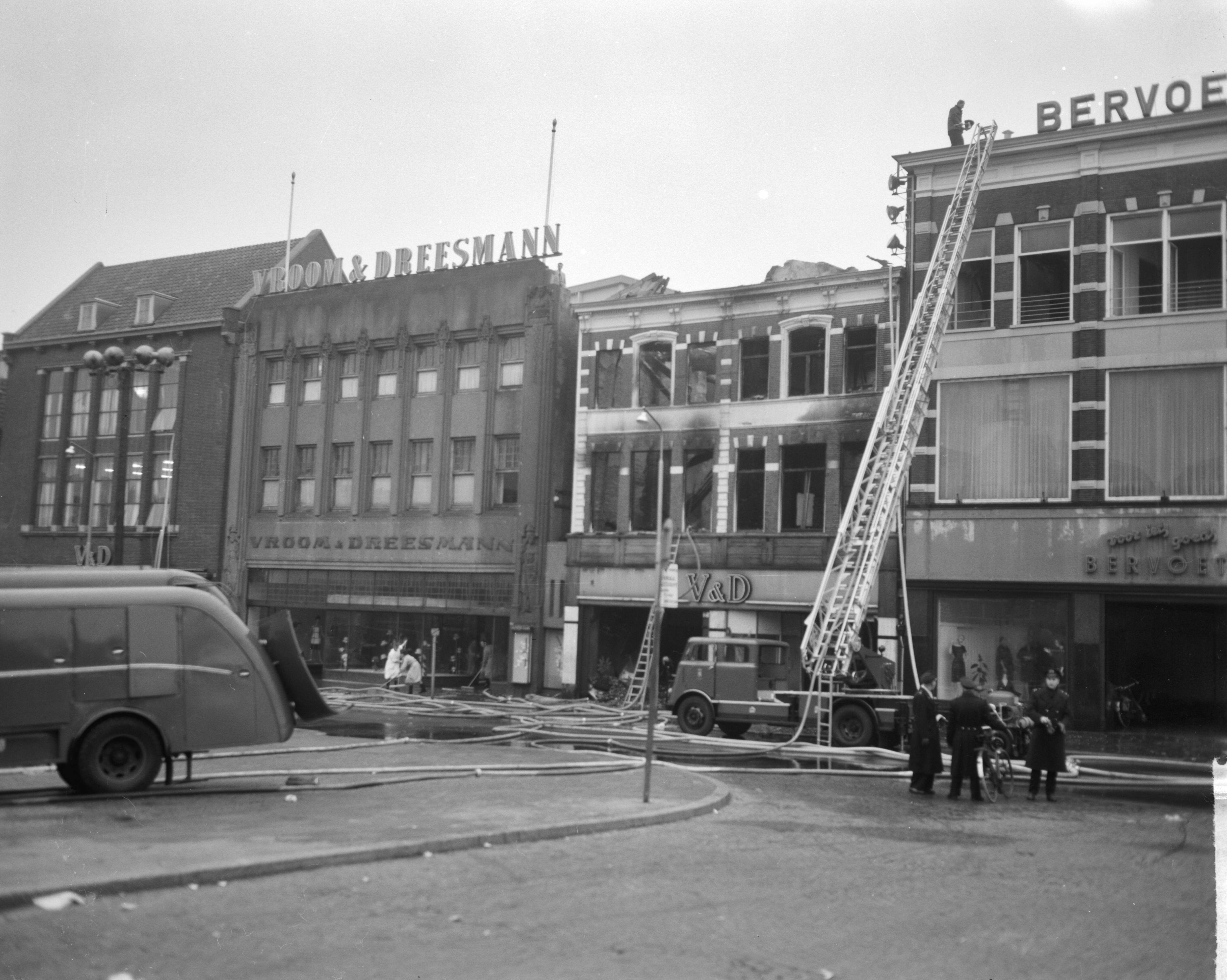 Fotocollectie Anefo — Brand bij V&D te Leeuwarden. Onbeschadigde confectie wordt in veiligheid gebracht — Foto: Bilsen, Joop van / Anefo. Licentie: Set B: Rechtenvrij / Publiek Domein. Bron: Nationaal Archief. http://hdl.handle.net/10648/aa2eda94-d0b4-102d-bcf8-003048976d84