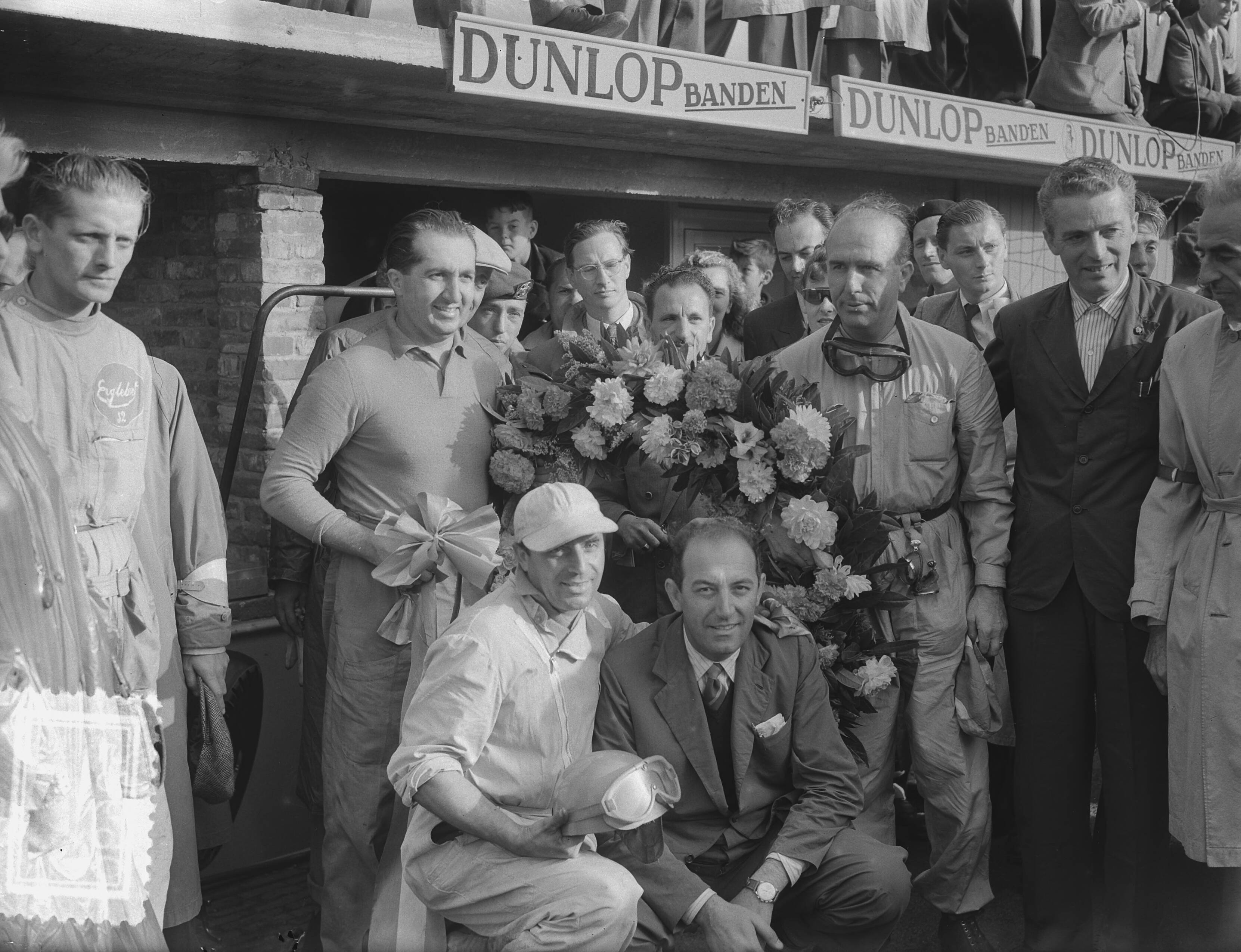 Grote Prijs van Nederland 1952 — Grote Prijs van Nederland op het circuit van Zandvoort. Winnaar Alberto Ascari (staand links met strik) poseert met zijn team van Scuderia Ferrari — Foto: Bilsen, Joop van / Anefo. Licentie: Set B: Rechtenvrij / Publiek Domein. Bron: Nationaal Archief. http://hdl.handle.net/10648/a8fe73a0-d0b4-102d-bcf8-003048976d84