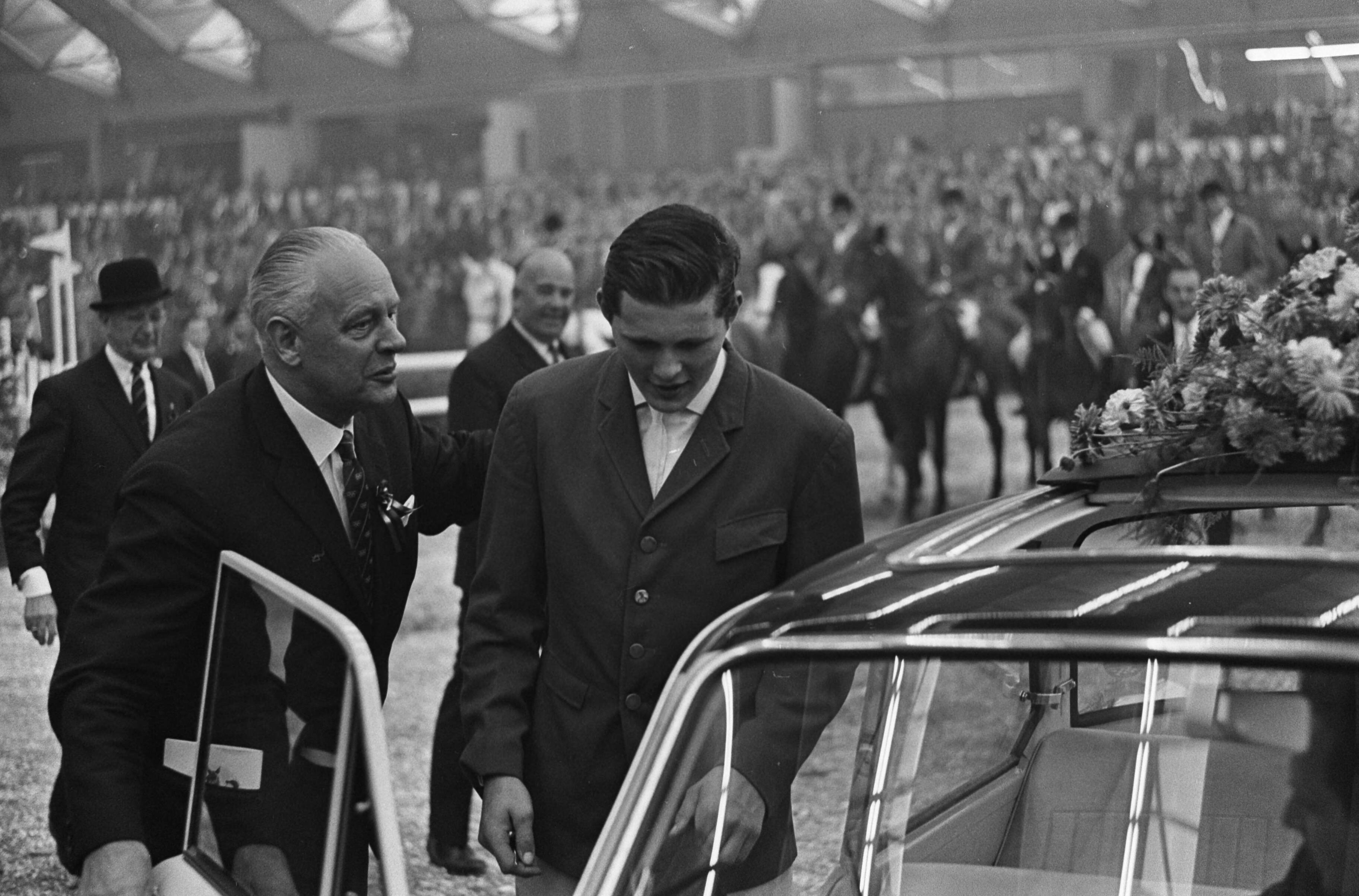 Jumping Amsterdam 1965 in de RAI te Amsterdam — Winnaar van Grote Prijs van Amsterdam, Gerd Wiltfang, tijdens zijn huldiging bij een Daf-personenauto (opdracht DAF) — Foto: Fotograaf Onbekend / Anefo. Licentie: Set B: Rechtenvrij / Publiek Domein. Bron: Nationaal Archief. http://hdl.handle.net/10648/aac8e8f0-d0b4-102d-bcf8-003048976d84