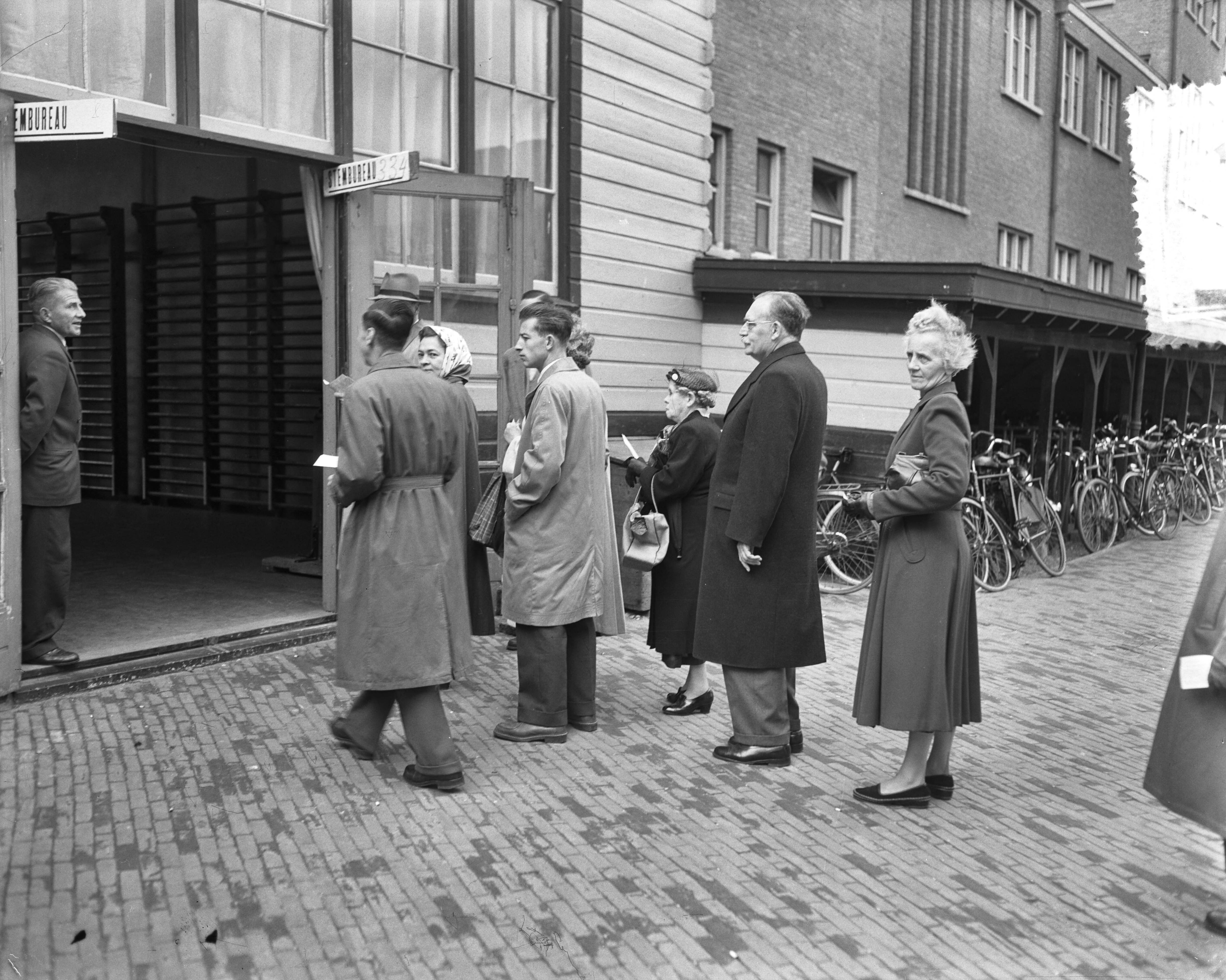 Stemmen voor de Tweede Kamerverkiezingen 1956 — Premier Drees in de rij bij het stembureau in Den Haag — Foto: Pot, Harry / Anefo. Licentie: Set B: Rechtenvrij / Publiek Domein. Bron: Nationaal Archief. http://hdl.handle.net/10648/a949bf36-d0b4-102d-bcf8-003048976d84