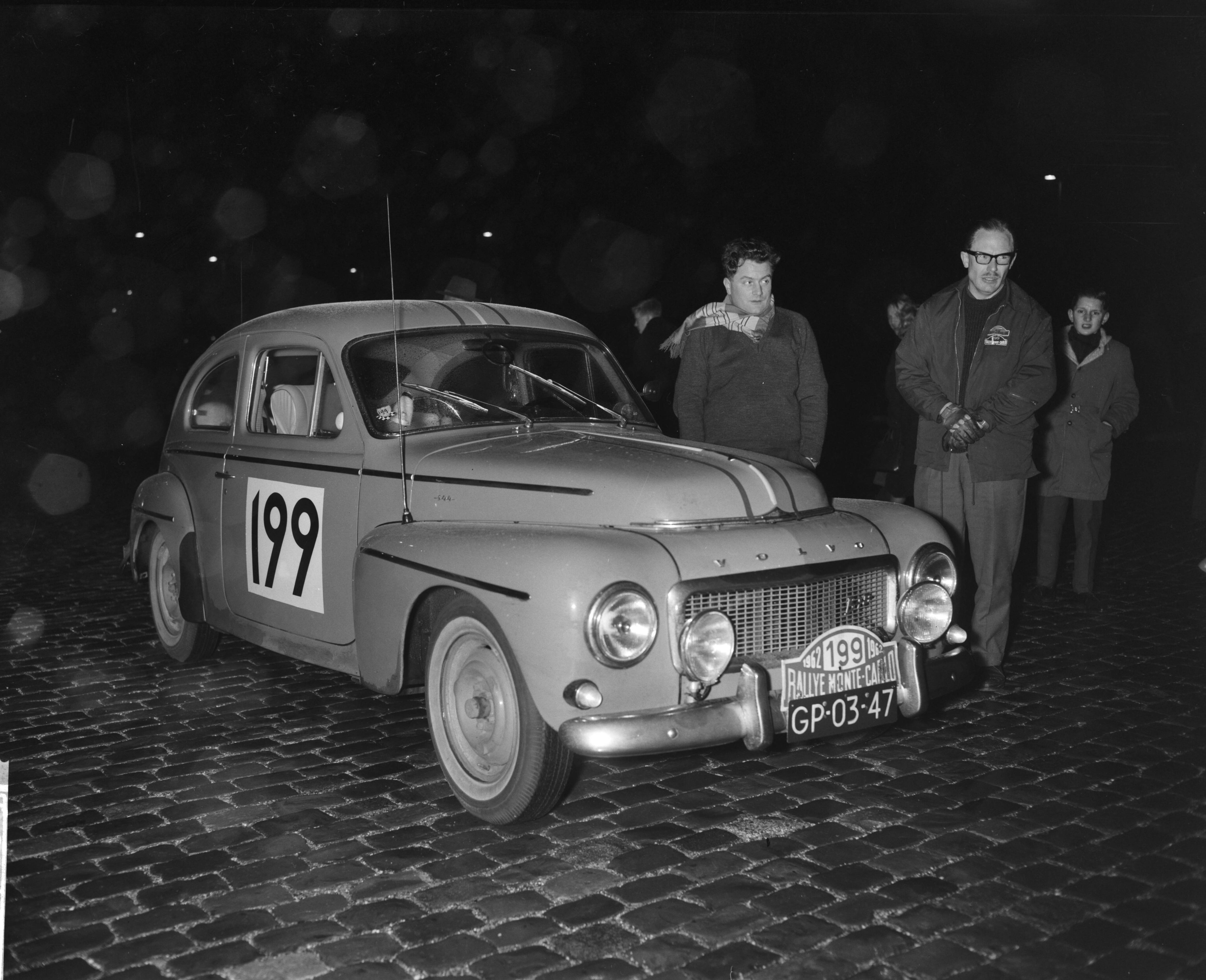 Fotocollectie Anefo — Deelnemers Rally Monte Carlo tijdcontrole in Scheveningen. Johannes Michielen en Johannes A. Linschoten met hun Volvo 1780 (startnummer 199) — Foto: Bilsen, Joop van / Anefo. Licentie: Set B: Rechtenvrij / Publiek Domein. Bron: Nationaal Archief. http://hdl.handle.net/10648/a9f4f702-d0b4-102d-bcf8-003048976d84