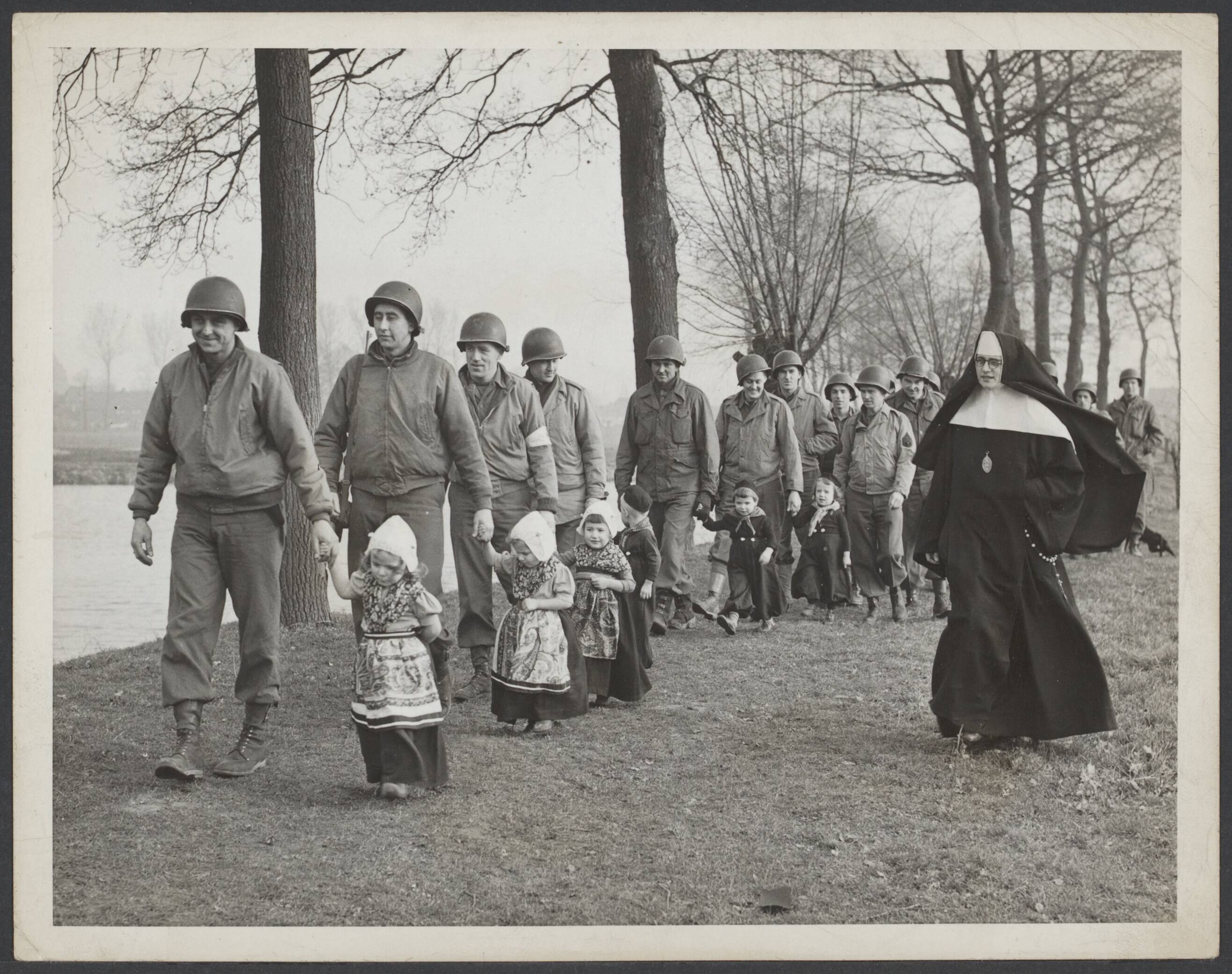 Bevrijding Nederland 1944 — Amerikaanse militairen met kleine Nederlandse kinderen tijdens een ochtendwandeling bij kasteel Hoensbroek. Daar worden 145 kinderen verzorgd door nonnen. De nabij gelegerde Amerikanen assisteren hen daarbij. — Foto: International News Photos [INP]. Licentie: Set B: Rechtenvrij / Publiek Domein. Bron: Nationaal Archief. http://hdl.handle.net/10648/2cc401c9-75dd-2614-a925-3dbcab0f0830