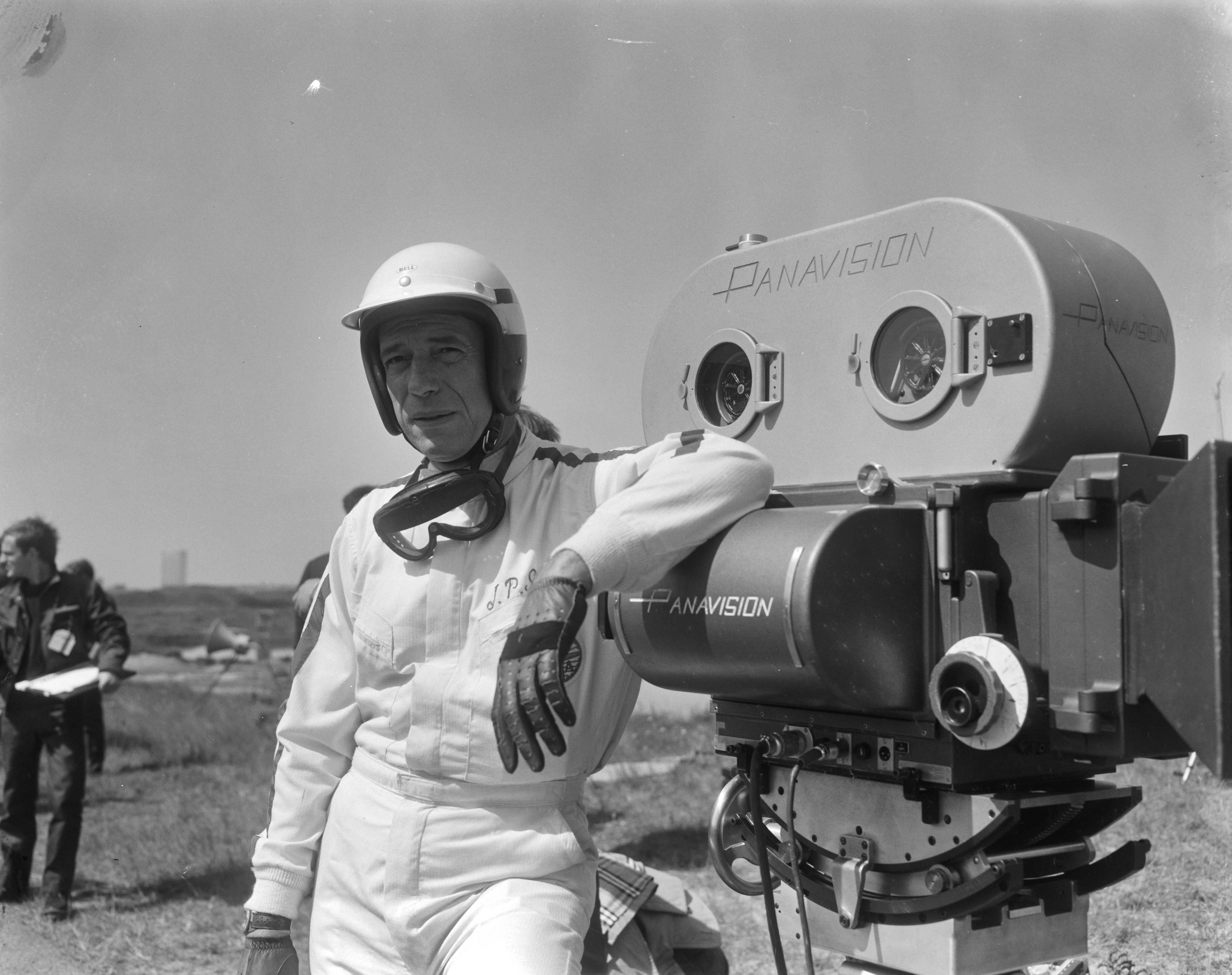 Fotocollectie Anefo — Cineramafilm "Grand Prix", filmopnames op het circuit van Zandvoort, Yves Montand [als coureur Jean-Pierre Sarti] bij de filmcamera — Foto: Bilsen, Joop van / Anefo. Licentie: Set B: Rechtenvrij / Publiek Domein. Bron: Nationaal Archief. http://hdl.handle.net/10648/aaf3c2aa-d0b4-102d-bcf8-003048976d84