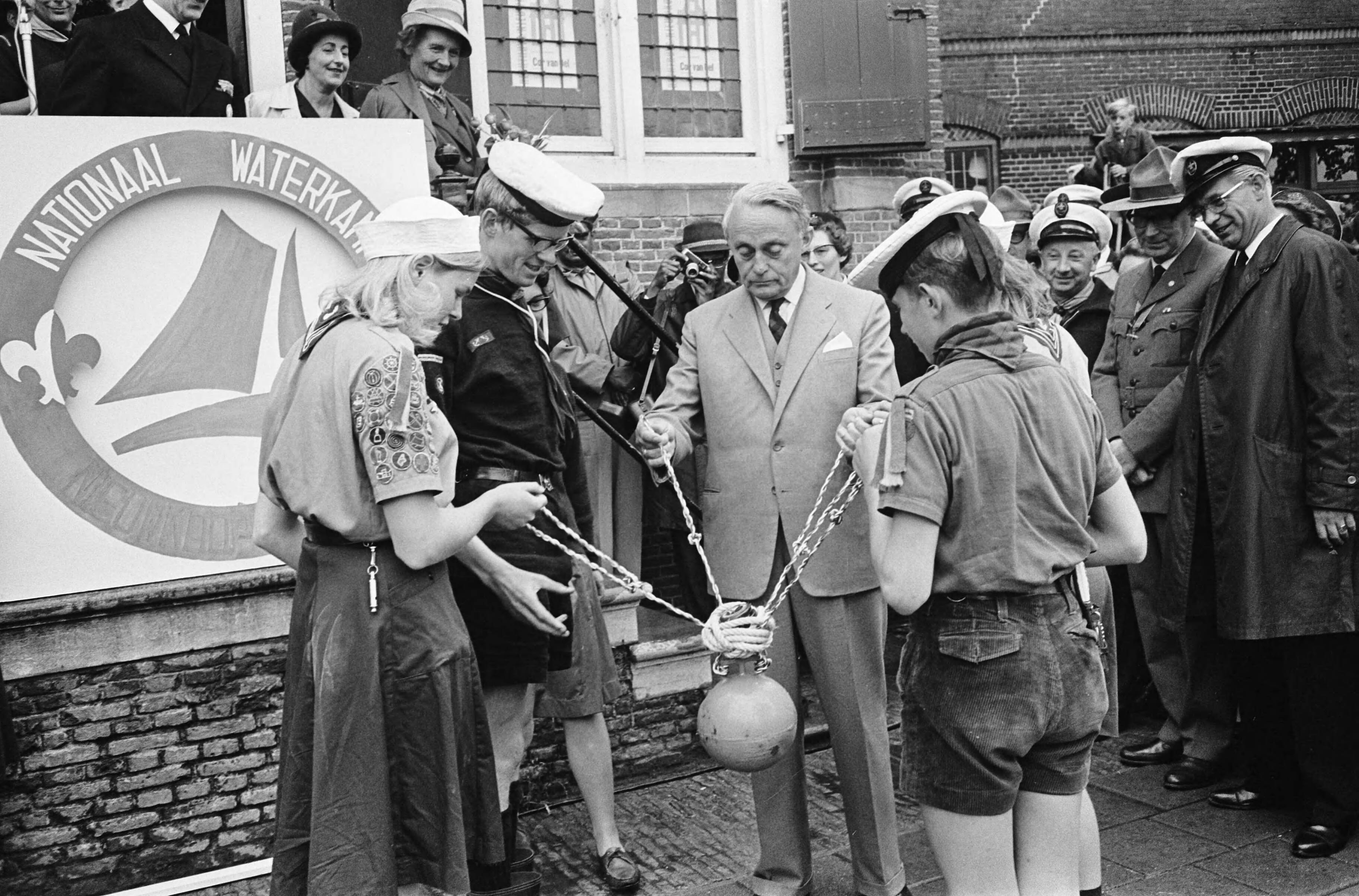 Fotocollectie Anefo — Nationaal Waterkamp in Nieuwkoop door de Commissaris van de Koningin in Zuid-Holland, mr. J. Klaasesz, geopend. Van zeeverkenners ontvangt hij een ankerboei — Foto: Koch, Eric / Anefo. Licentie: Set B: Rechtenvrij / Publiek Domein. Bron: Nationaal Archief. http://hdl.handle.net/10648/aab776b0-d0b4-102d-bcf8-003048976d84
