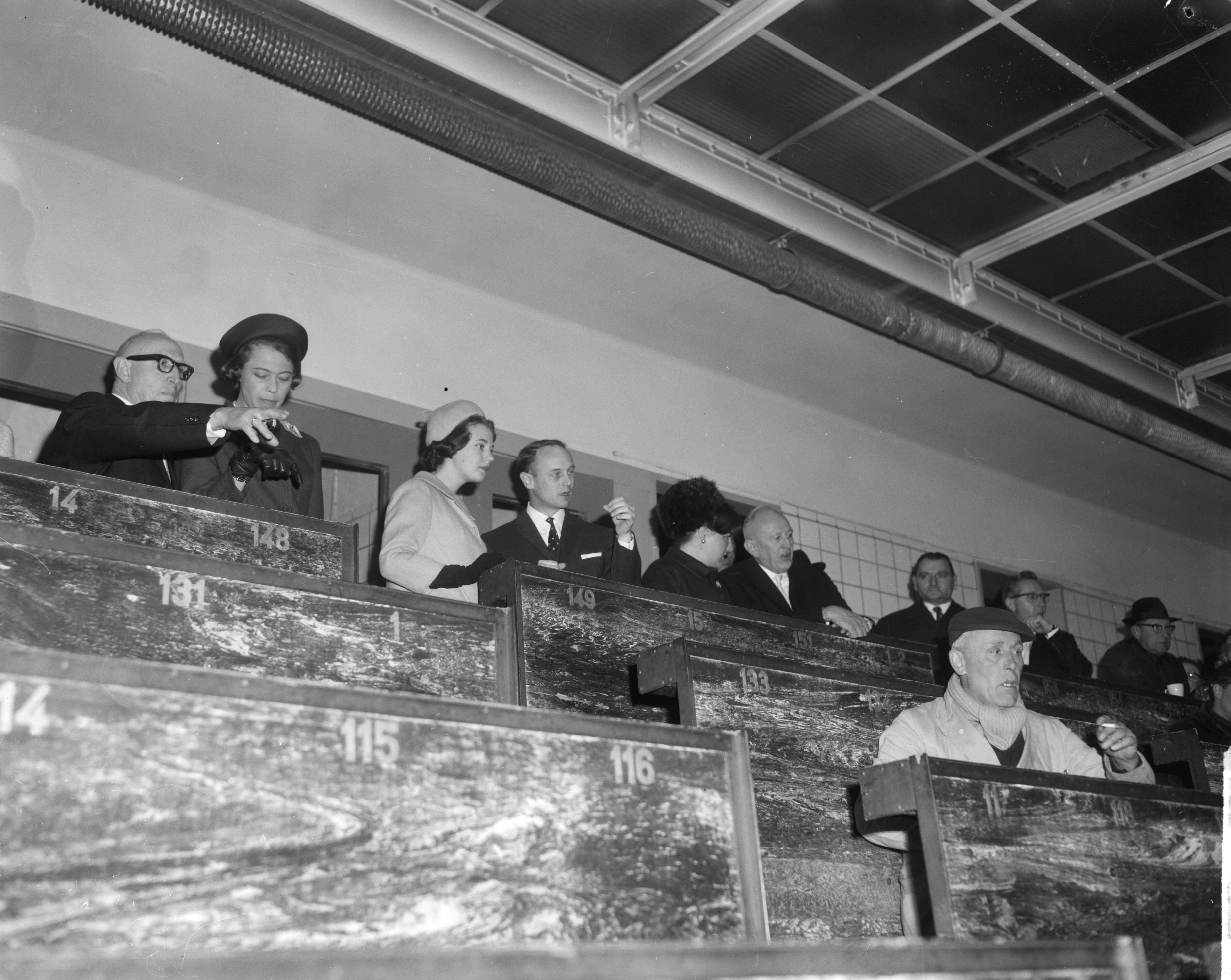 Bezoek van prinses Benedikte van Denemarken aan Nederland (1965) — De Deense prinses Benedikte en prinses Margriet bezochten de bloemenveiling te Aalsmeer, de prinsessen tijdens de veiling. In het midden de voorzitter van de bloemenveiling dhr. Eveleens — Foto: Bilsen, Joop van / Anefo. Licentie: Set B: Rechtenvrij / Publiek Domein. Bron: Nationaal Archief. http://hdl.handle.net/10648/aa9ea1da-d0b4-102d-bcf8-003048976d84