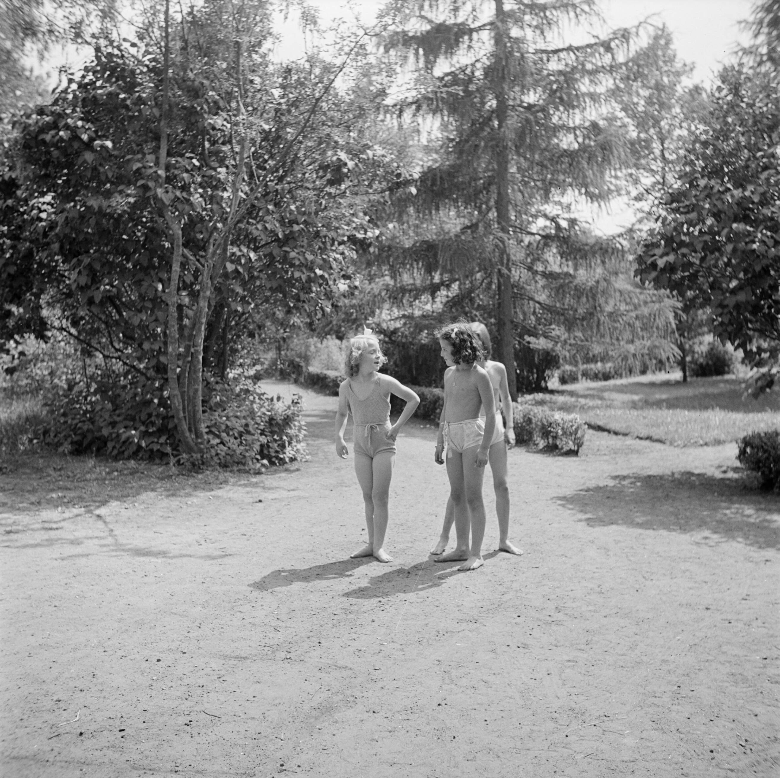Prinses Beatrix en prinses Irene op de Werkplaats Kindergemeenschap van Kees Boeke te Bilthoven — Prinses Irene met twee klasgenoten in de tuin — Foto: Poll, Willem van de. Licentie: Set B: Rechtenvrij / Publiek Domein. Bron: Nationaal Archief. http://hdl.handle.net/10648/aee81186-d0b4-102d-bcf8-003048976d84