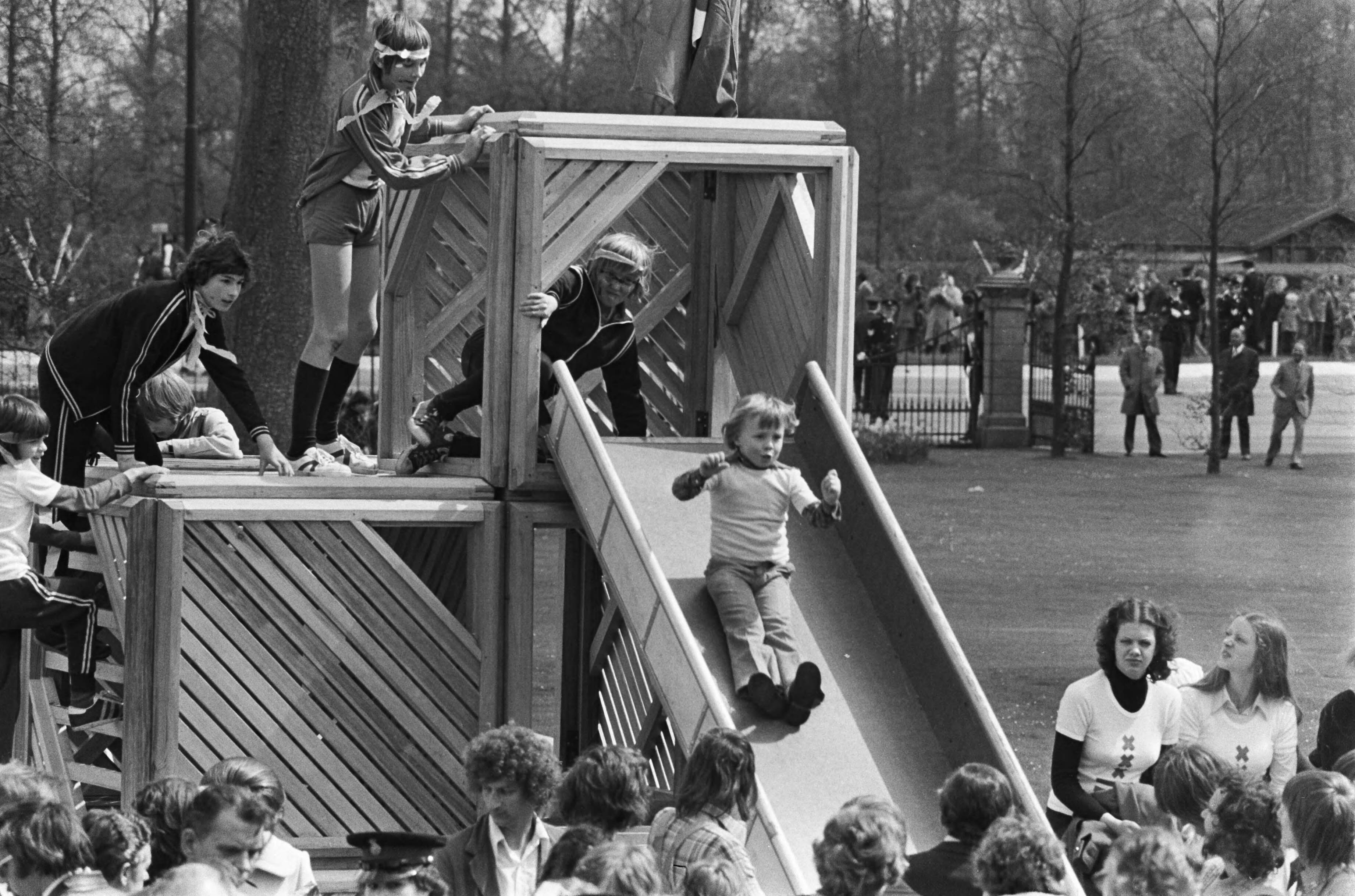 Defilé Paleis Soestdijk — Spelende prinsjes op de glijbaan — Foto: Verhoeff, Bert / Anefo. Licentie: Set B: Rechtenvrij / Publiek Domein. Bron: Nationaal Archief. http://hdl.handle.net/10648/ac67aa84-d0b4-102d-bcf8-003048976d84