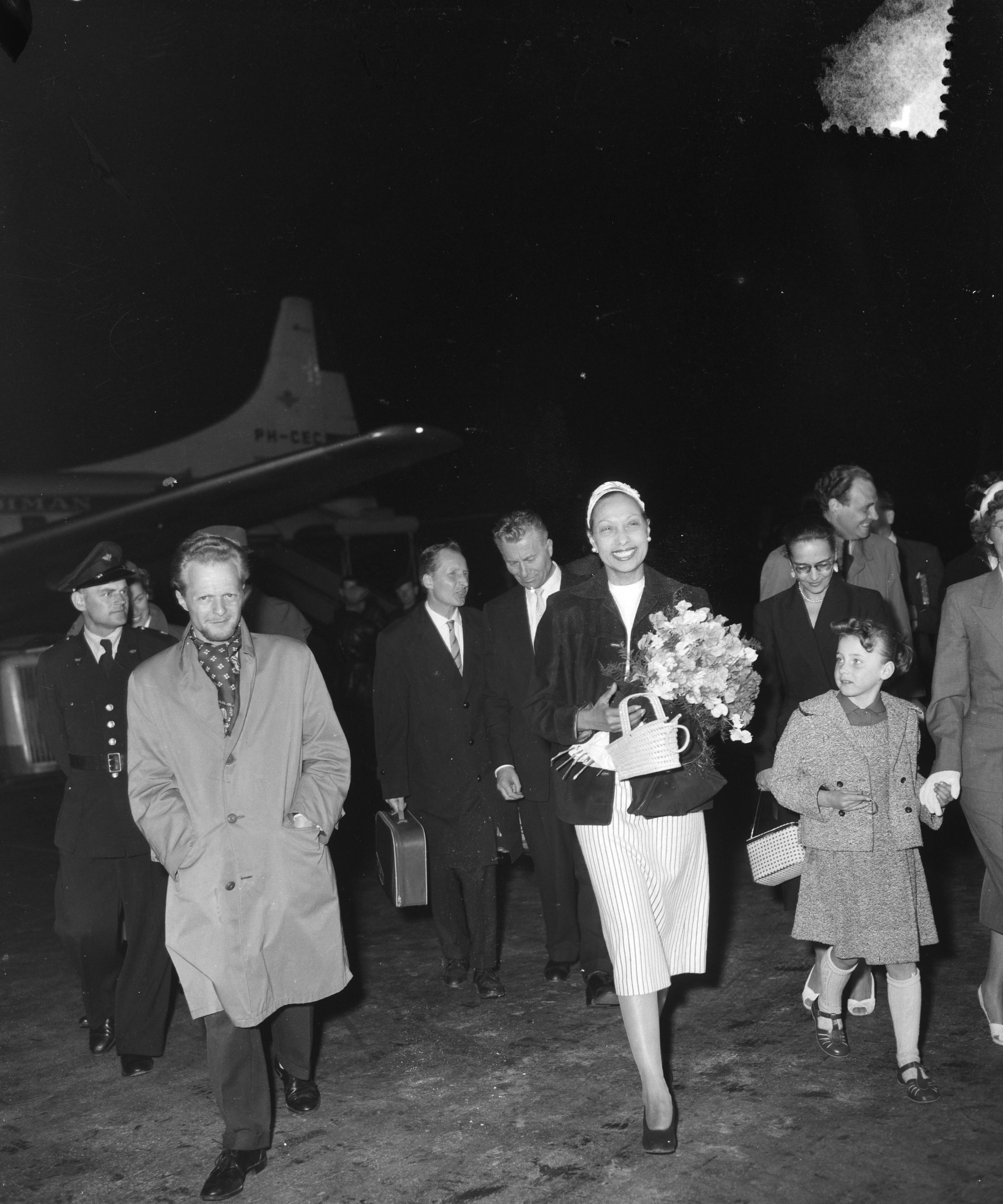 Fotocollectie Anefo — Aankomst van Josephine Baker op Schiphol. Achter haar de directeur van Theater Carré, Alex Wunnink jr. — Foto: Bilsen, Joop van / Anefo. Licentie: Set B: Rechtenvrij / Publiek Domein. Bron: Nationaal Archief. http://hdl.handle.net/10648/a947927e-d0b4-102d-bcf8-003048976d84