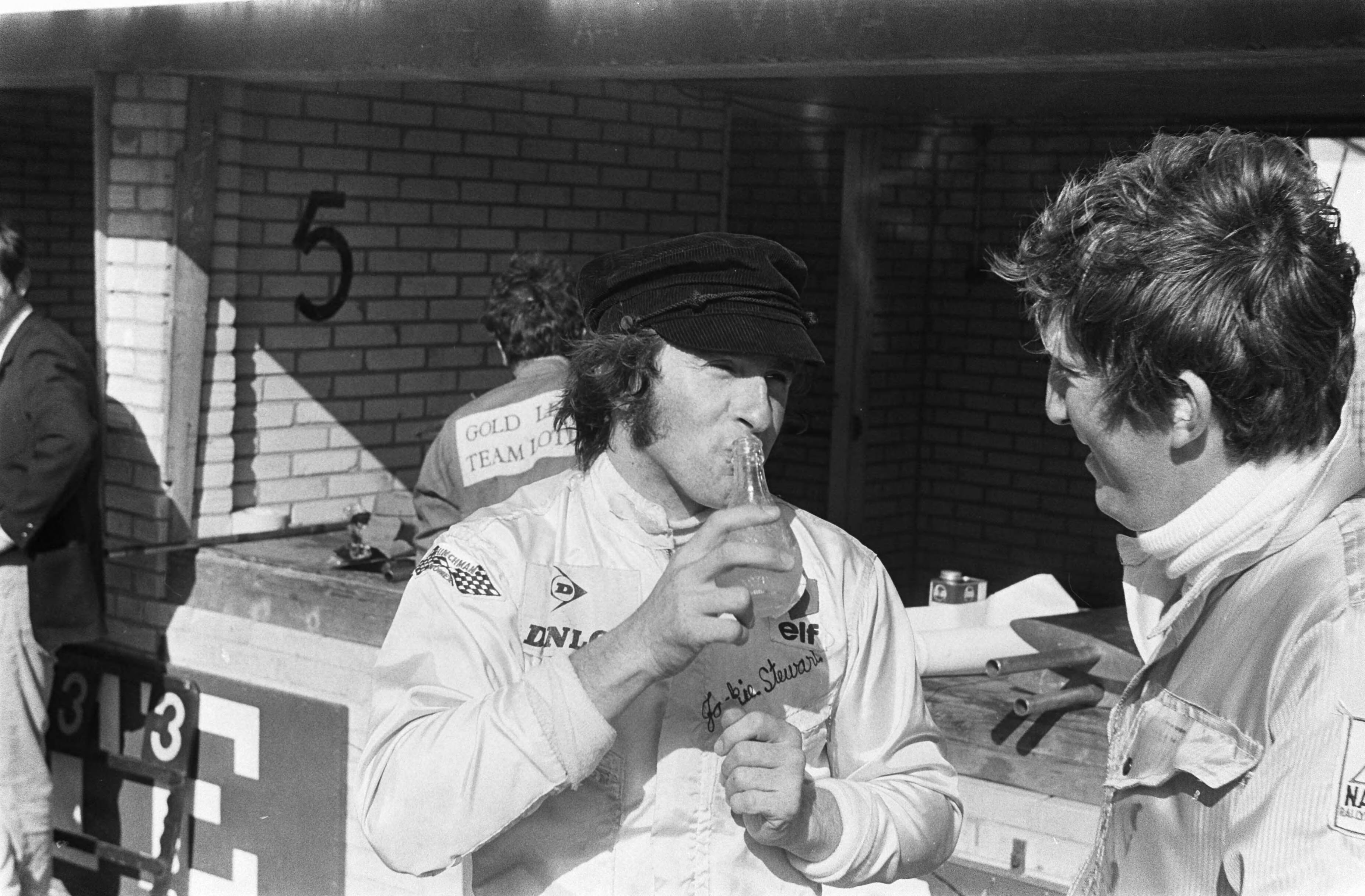 Grand Prix Zandvoort 1969 — Jackie Stewart drinkt een flesje limonade — Foto: Fotograaf Onbekend / Anefo. Licentie: Set B: Rechtenvrij / Publiek Domein. Bron: Nationaal Archief. http://hdl.handle.net/10648/ab6f3764-d0b4-102d-bcf8-003048976d84