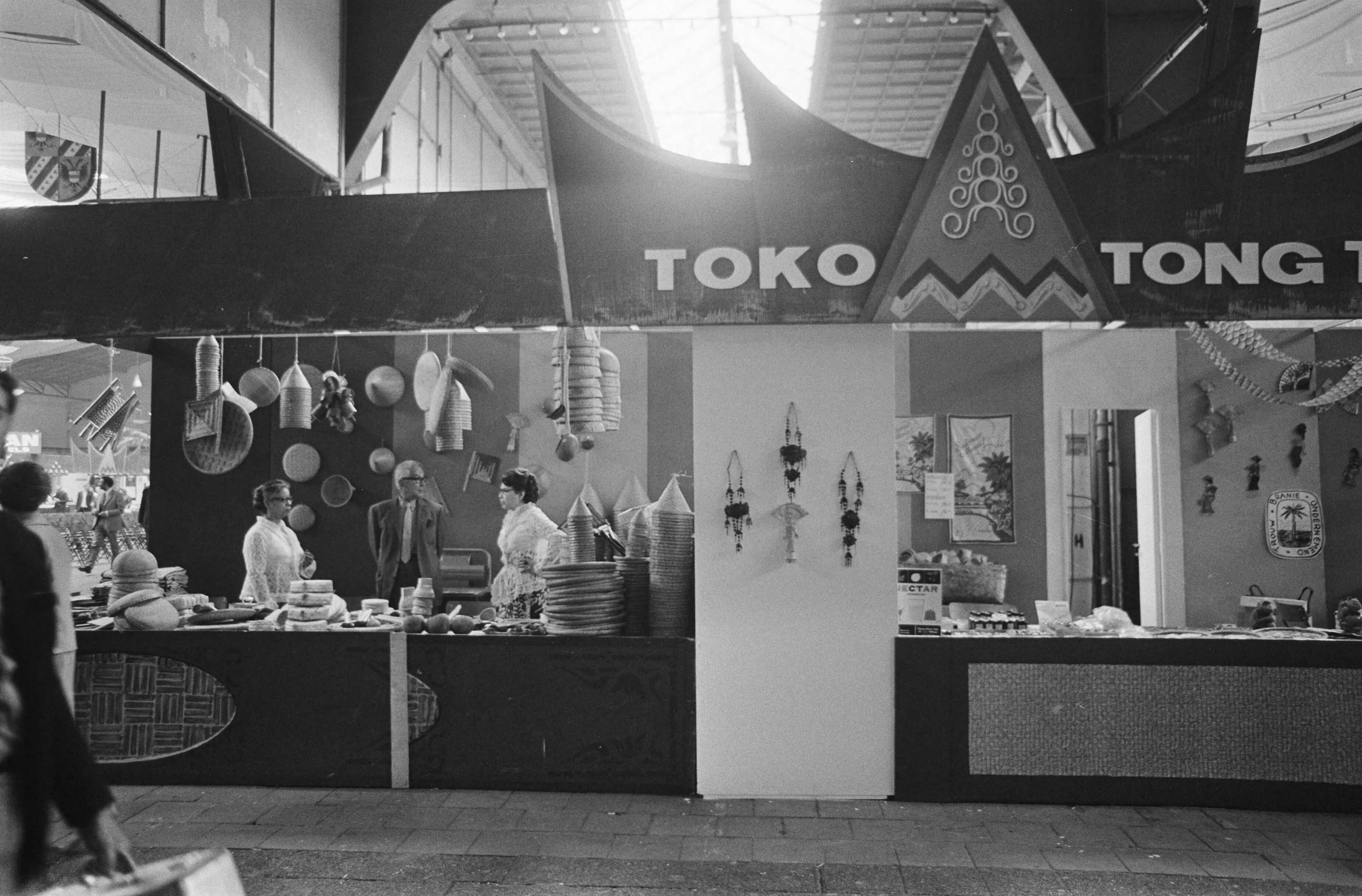 11e Pasar Malam te Den Haag — Een toko — Foto: Fotograaf Onbekend / Anefo. Licentie: Set B: Rechtenvrij / Publiek Domein. Bron: Nationaal Archief. http://hdl.handle.net/10648/ab70122e-d0b4-102d-bcf8-003048976d84