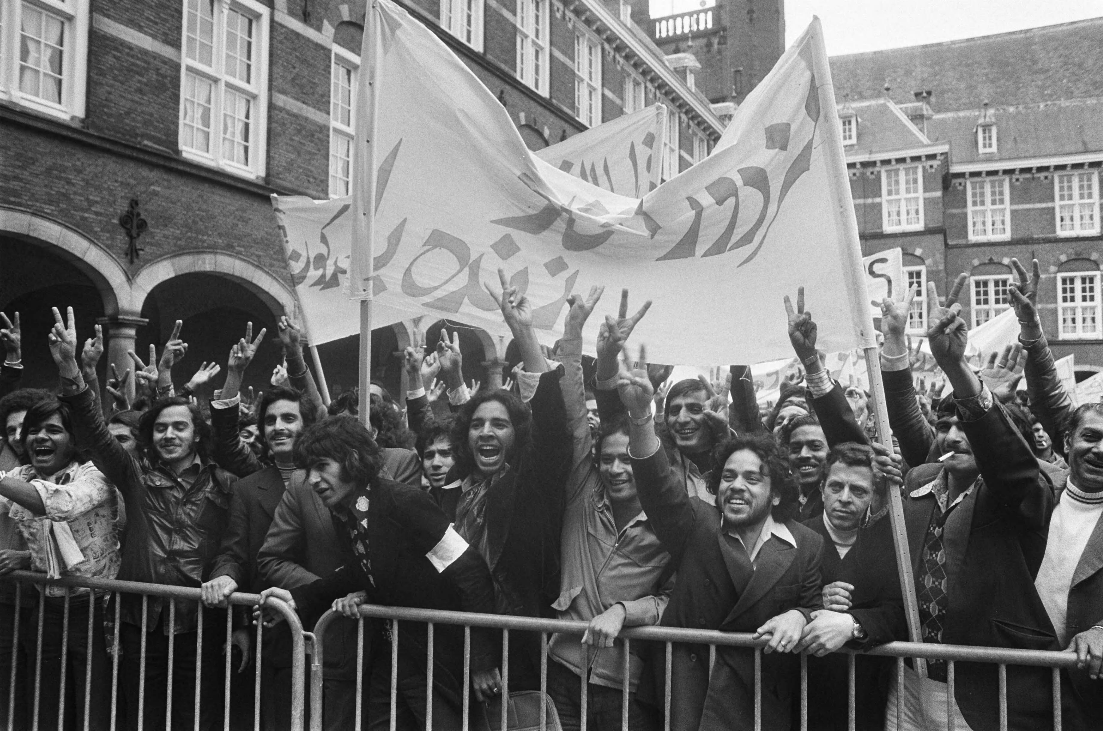 Demonstratie van buitenlandse werknemers op het Binnenhof tegen de legaliseringsregeling — Den Haag|Zuid-Holland|demonstraties |spandoeken |legalisering |werknemers |buitenlanders |illegalen — Foto: Peters, Hans / Anefo. Licentie: Set B: Rechtenvrij / Publiek Domein. Bron: Nationaal Archief. http://hdl.handle.net/10648/ac672438-d0b4-102d-bcf8-003048976d84