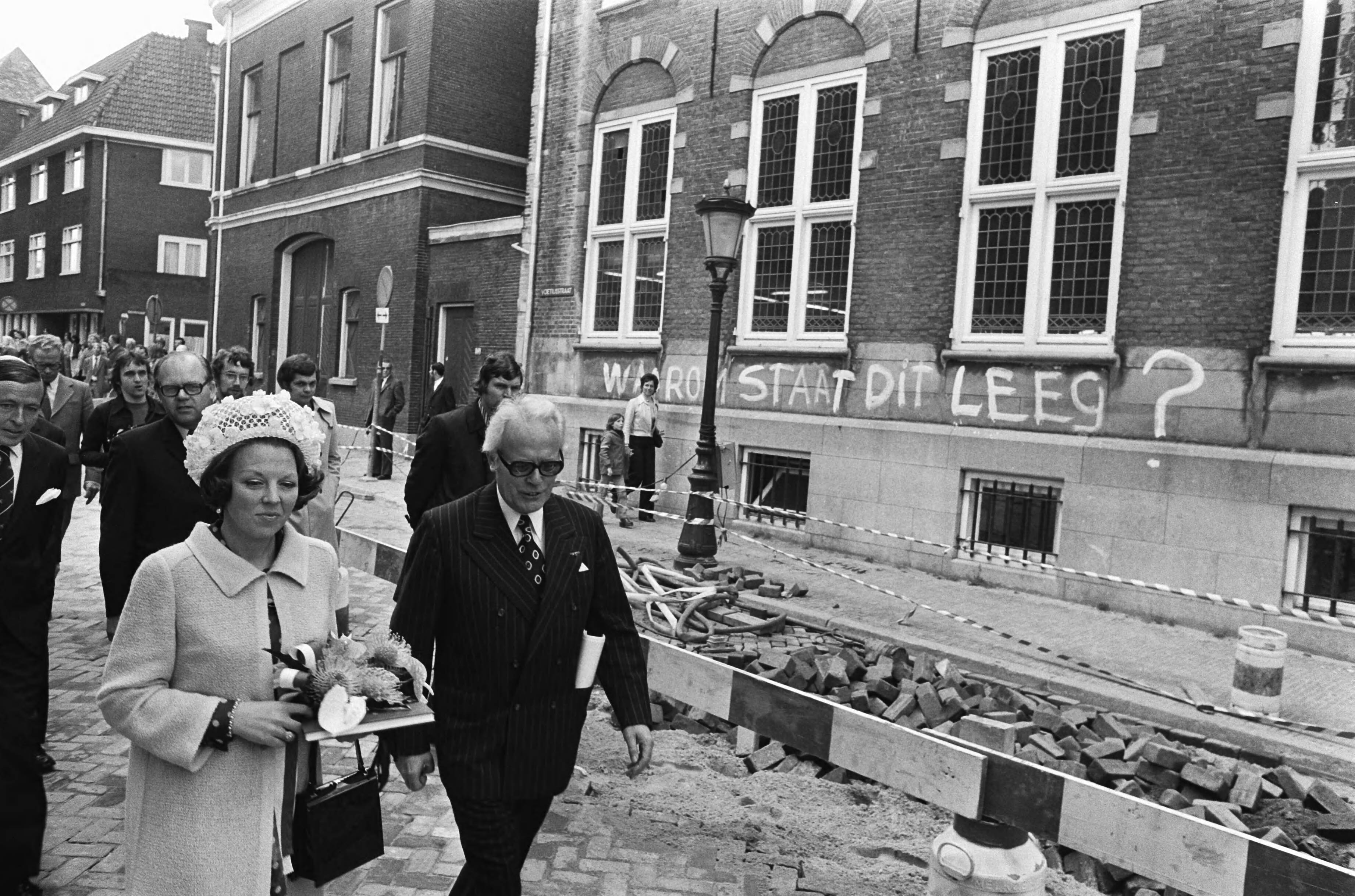 Prinses Beatrix en prins Claus wonen een bijzondere vergadering van Provinciale Staten bij in de Domkerk in Utrecht — Verdam (commissaris van de koningin in Utrecht), links naast hem half zichtbaar prinses Beatrix tijdens een wandeling buiten — Foto: Verhoeff, Bert / Anefo. Licentie: Set B: Rechtenvrij / Publiek Domein. Bron: Nationaal Archief. http://hdl.handle.net/10648/ac687d7e-d0b4-102d-bcf8-003048976d84