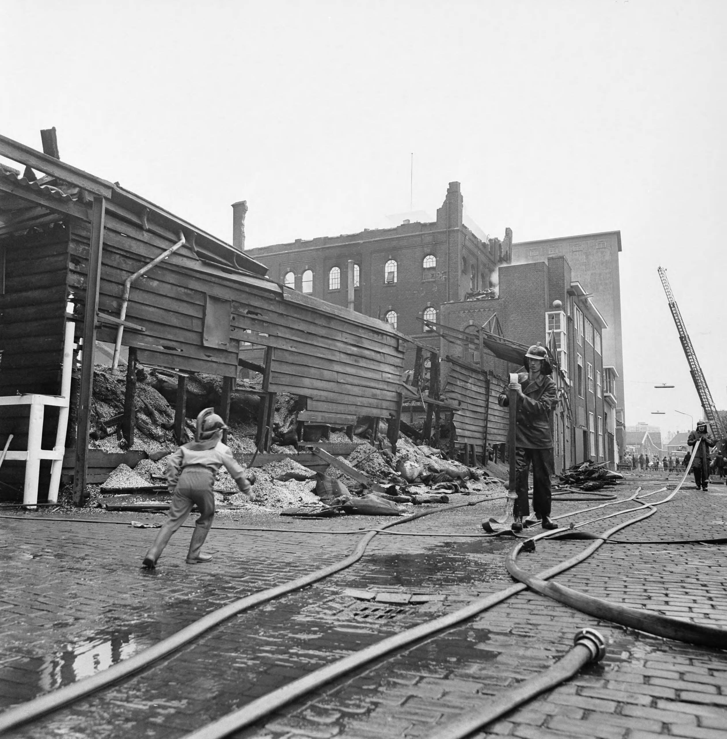Fotocollectie Anefo — Twee bedrijven in Zaandam uitgebrand; nablussingswerkzaamheden — Foto: Croes, Rob C. / Anefo. Licentie: Set B: Rechtenvrij / Publiek Domein. Bron: Nationaal Archief. http://hdl.handle.net/10648/aca4dcd8-d0b4-102d-bcf8-003048976d84