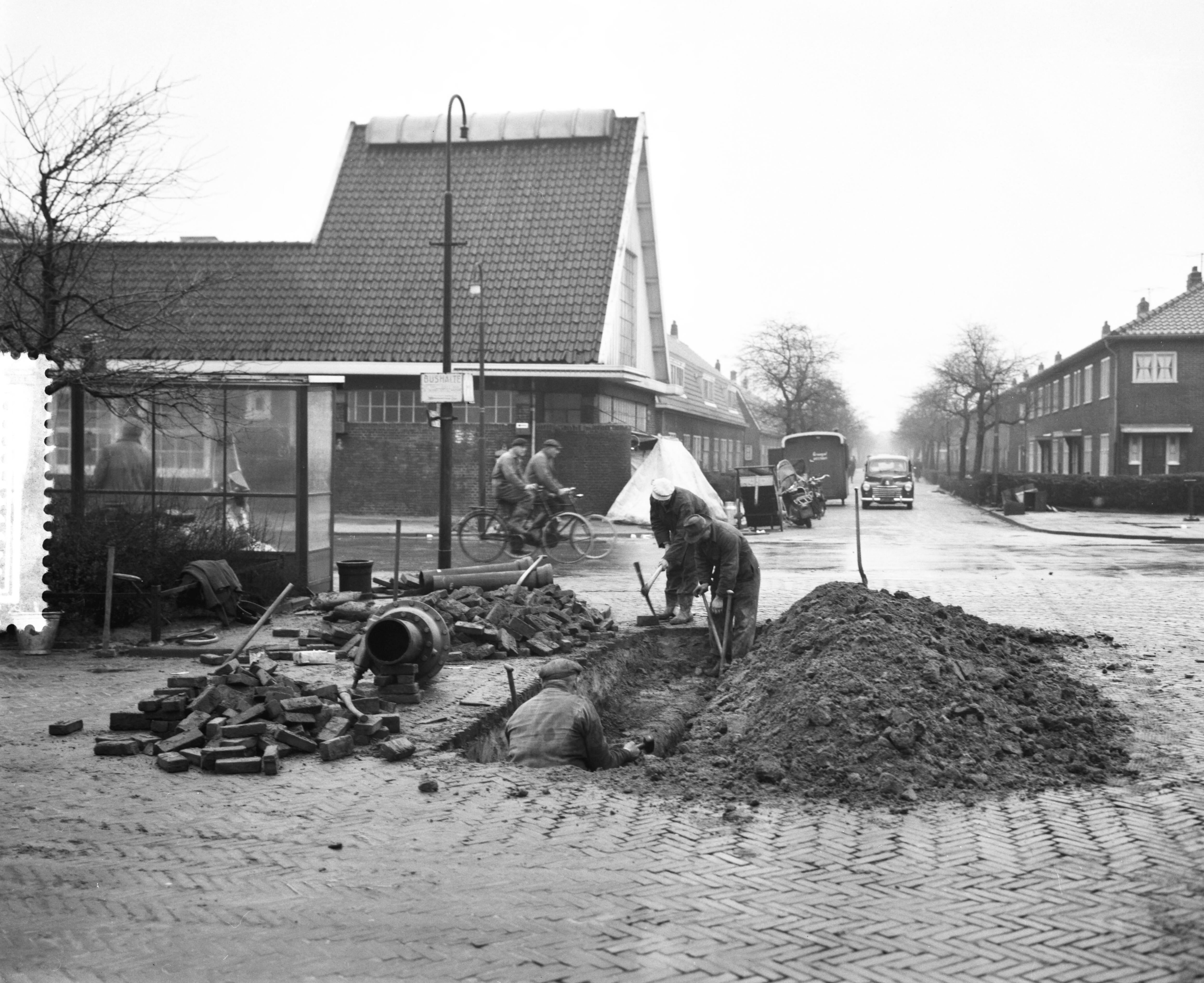 Ramp Tuindorp Oostzaan — Laatste voorbereiding terugkeer bewoners Oostzaan, stratenmakers — Foto: Behrens, Herbert F. / Anefo. Licentie: Set B: Rechtenvrij / Publiek Domein. Bron: Nationaal Archief. http://hdl.handle.net/10648/a9a6c7f8-d0b4-102d-bcf8-003048976d84