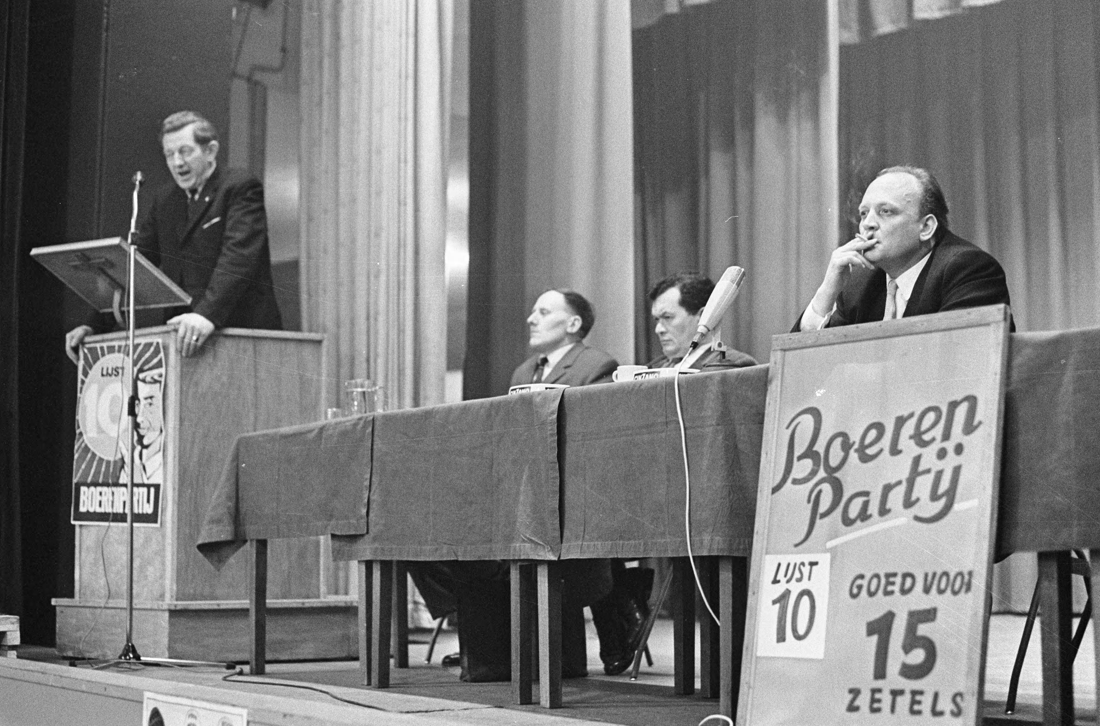 Fotocollectie Anefo — Affiches Boerenpartij goed voor 15 zetels, links Koekoek tijdens vergadering Den Haag , geheel rechts A. Dulfer voorzitter Boerenpartij Den Haag — Foto: Kroon, Ron / Anefo. Licentie: Set B: Rechtenvrij / Publiek Domein. Bron: Nationaal Archief. http://hdl.handle.net/10648/ab0eda72-d0b4-102d-bcf8-003048976d84