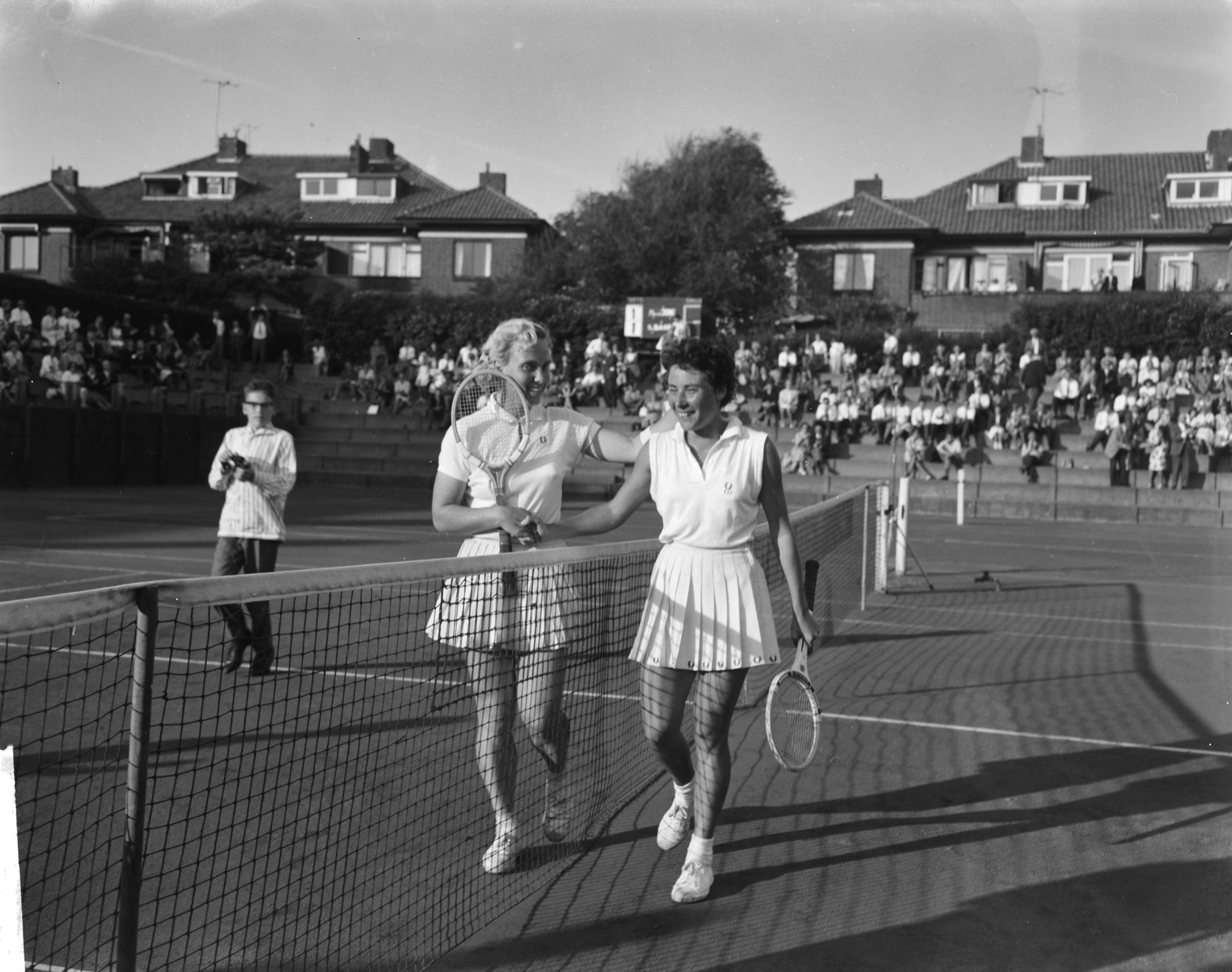 Fotocollectie Anefo — Nederlandse tenniskampioenschappen gespeeld op de METS-banen te Scheveningen. Eva de Jong, kampioen dames enkel en haar tegenstander Jetty Baars-Wienese (links) — Foto: Bilsen, Joop van / Anefo. Licentie: Set B: Rechtenvrij / Publiek Domein. Bron: Nationaal Archief. http://hdl.handle.net/10648/aa143b8a-d0b4-102d-bcf8-003048976d84