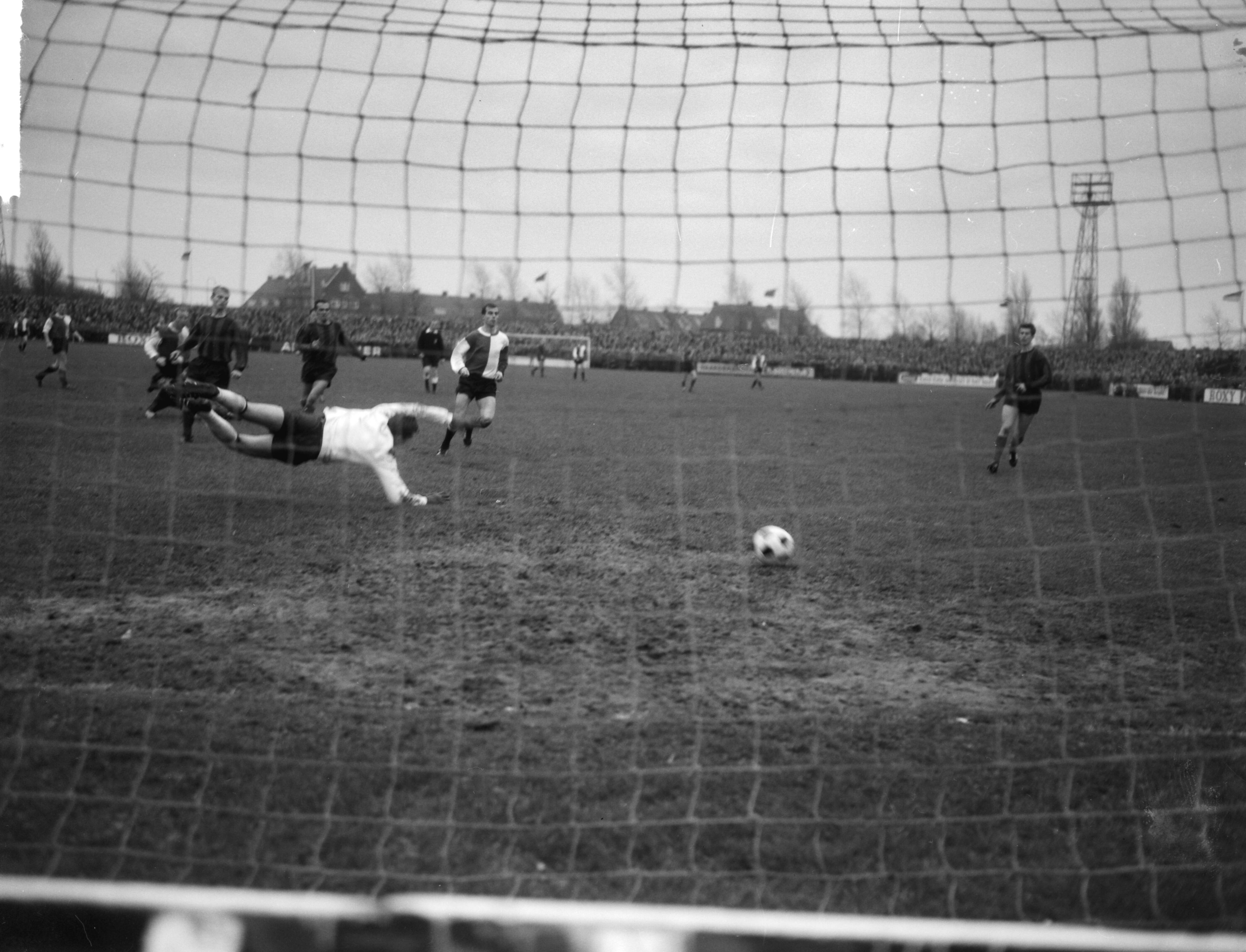 Fotocollectie Anefo — Bekervoetbal. EDO tegen Feijenoord 1-3. Spelmoment, doelpunt voor Feijenoord, keeper Ton Amema van EDO duikt tevergeefs. In het midden Coen Moulijn (Feijenoord) — Foto: Bilsen, Joop van / Anefo. Licentie: Set B: Rechtenvrij / Publiek Domein. Bron: Nationaal Archief. http://hdl.handle.net/10648/aa861ed0-d0b4-102d-bcf8-003048976d84