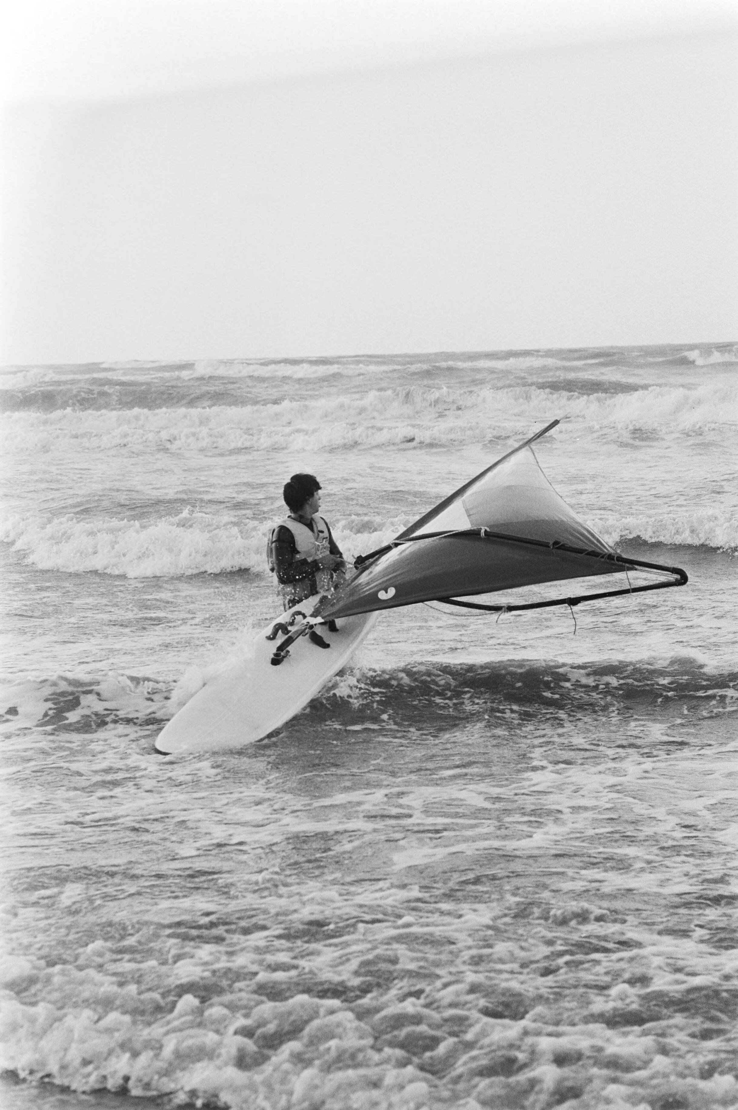 Fotocollectie Anefo — Ondanks de harde tot stormachtige wind waren er nog vrij veel wandelaars op de boulevard van Scheveningen, surfer — Foto: Antonisse, Marcel / Anefo. Licentie: Set B: Rechtenvrij / Publiek Domein. Bron: Nationaal Archief. http://hdl.handle.net/10648/acf17a8e-d0b4-102d-bcf8-003048976d84