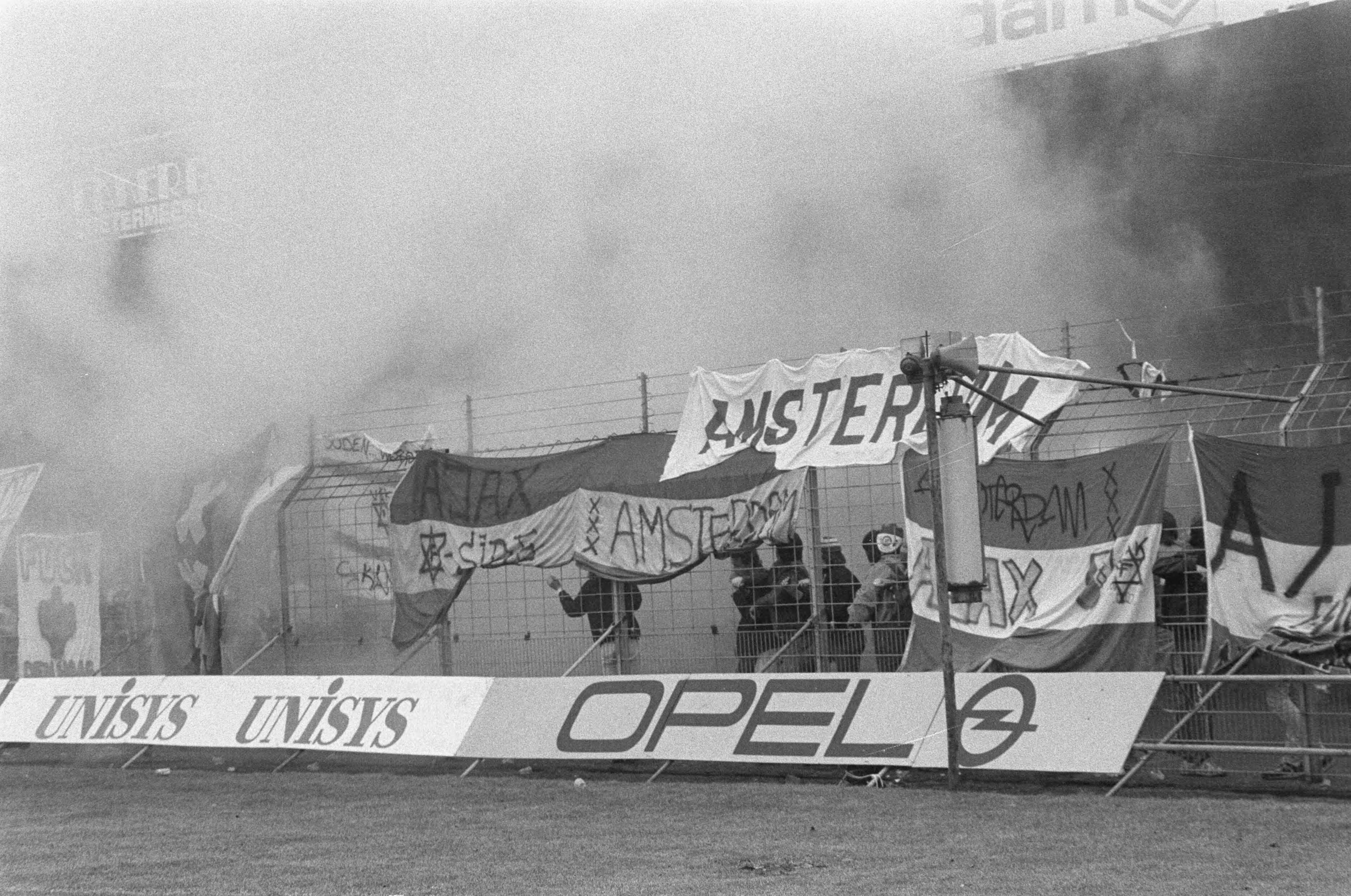 Fotocollectie Anefo — Supportersrellen tijdens Den Haag tegen Ajax in Den Haag ; Ajax-spandoeken — Foto: Molendijk, Bart / Anefo. Licentie: Set B: Rechtenvrij / Publiek Domein. Bron: Nationaal Archief. http://hdl.handle.net/10648/ad5d6776-d0b4-102d-bcf8-003048976d84