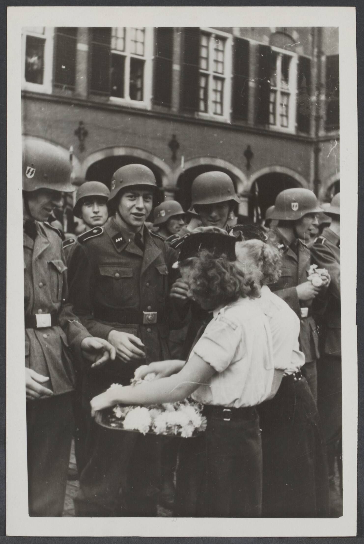 Vrijwilligers Legioen Nederland — Vertrekkenden van het Vrijwilligers Legioen Nederland krijgen bloemen van meisjes van de Nationale Jeugdstorm op het Binnenhof te Den Haag — Foto: Fotodienst der NSB / N.V. Polygoon. Licentie: Set B: Rechtenvrij / Publiek Domein. Bron: Nationaal Archief. http://hdl.handle.net/10648/a3eabbe5-5557-8a46-90f1-286a6d7049ef