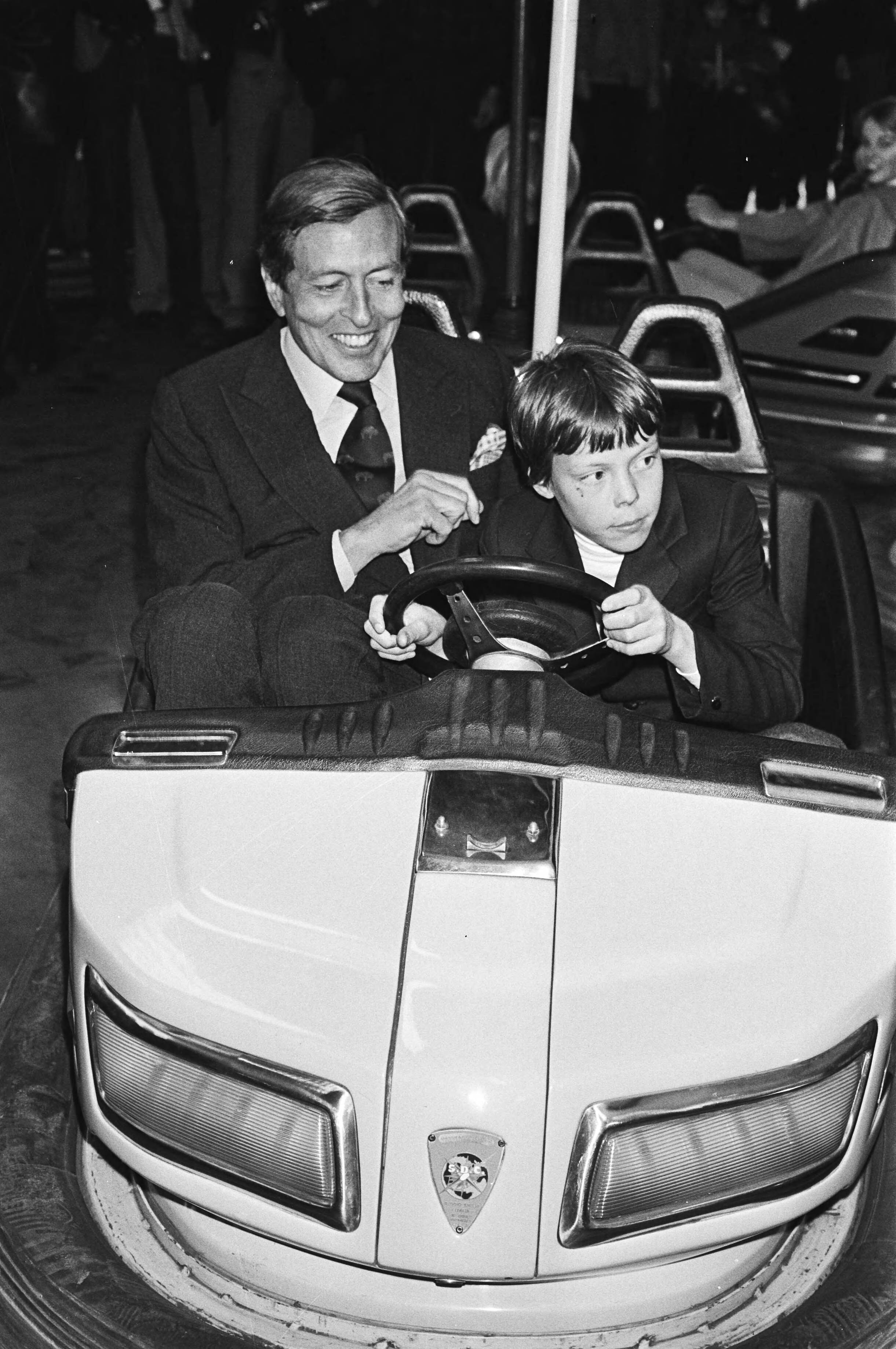 Fotocollectie Anefo — Viering Koninginnedag in Breda, Prins Claus en Constantijn op de kermis in Breda tijdens een ritje in de botsautootje — Foto: Croes, Rob C. / Anefo. Licentie: Set B: Rechtenvrij / Publiek Domein. Bron: Nationaal Archief. http://hdl.handle.net/10648/acfabc66-d0b4-102d-bcf8-003048976d84