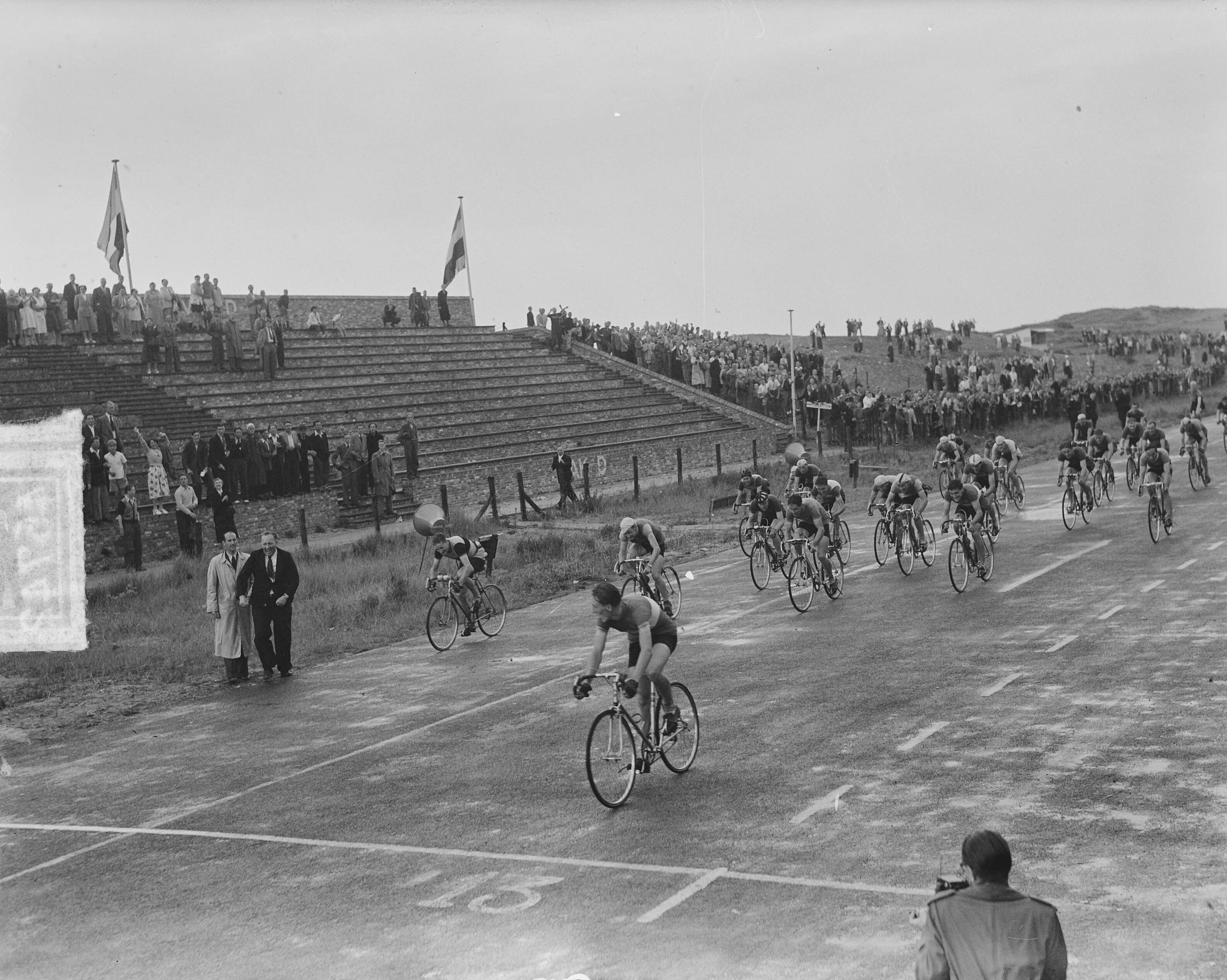 Nederlands kampioenschap wielrennen voor amateurs 1951 — Nederlands kampioenschap wielrennen voor amateurs op het circuit van Zandvoort. Finish. De eindsprint wordt gewonnen door Piet de Roon — Foto: Noske, J.D. / Anefo. Licentie: Set B: Rechtenvrij / Publiek Domein. Bron: Nationaal Archief. http://hdl.handle.net/10648/a8ecc95c-d0b4-102d-bcf8-003048976d84