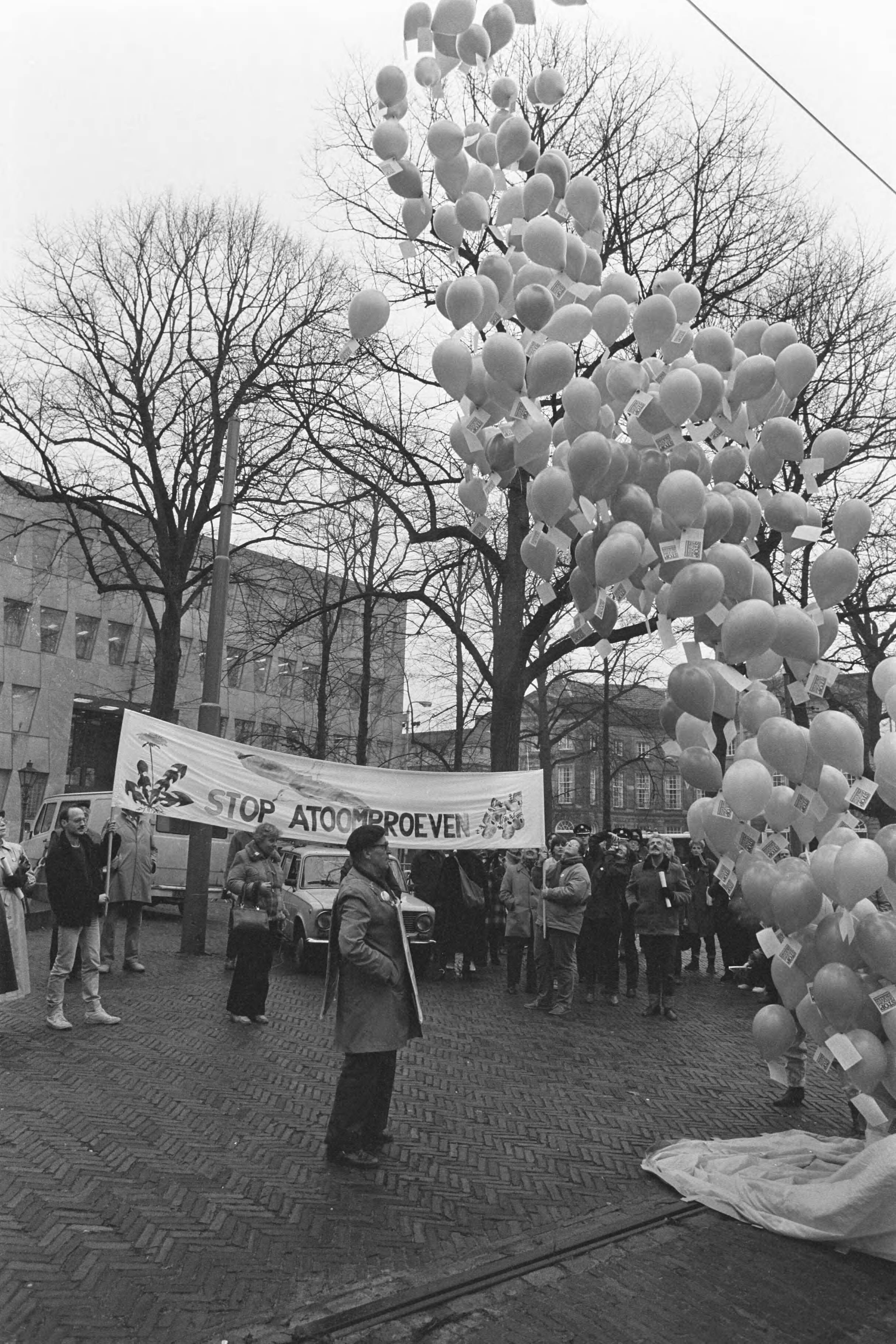 Fotocollectie Anefo — Demonstratie tegen hervatting onderaardse kernproeven voor VS ambassade in Den Haag — Foto: Bogaerts, Rob / Anefo. Licentie: Set B: Rechtenvrij / Publiek Domein. Bron: Nationaal Archief. http://hdl.handle.net/10648/ad5c4814-d0b4-102d-bcf8-003048976d84