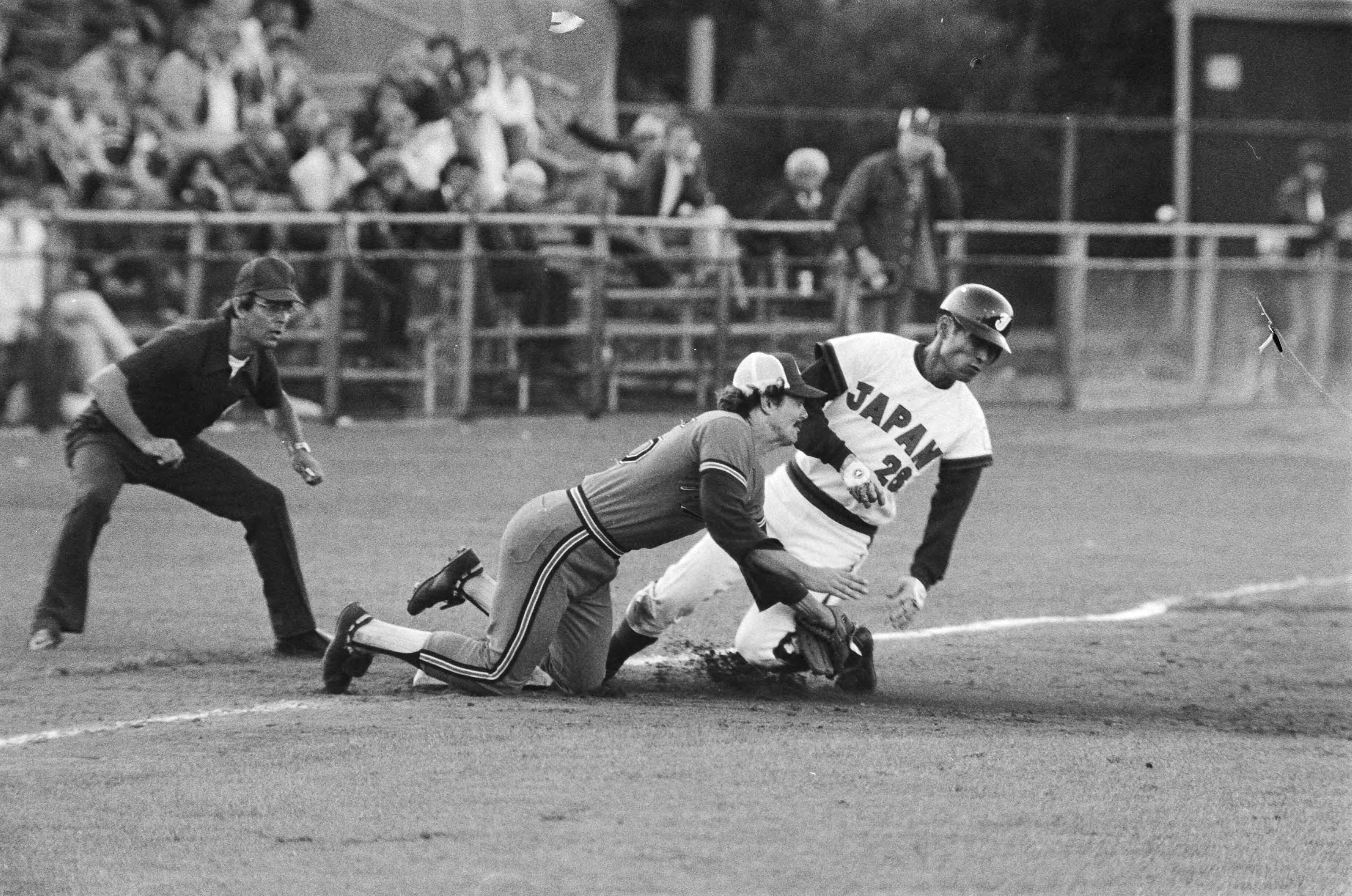 Fotocollectie Anefo — Haarlemse honkbalweek Nederland tegen Japan; Harm Horema (l) tikt Seki uit. Scheidsrechter is Hans Corpeleijn — Foto: Verhoeff, Bert / Anefo. Licentie: Set B: Rechtenvrij / Publiek Domein. Bron: Nationaal Archief. http://hdl.handle.net/10648/acba1e7c-d0b4-102d-bcf8-003048976d84
