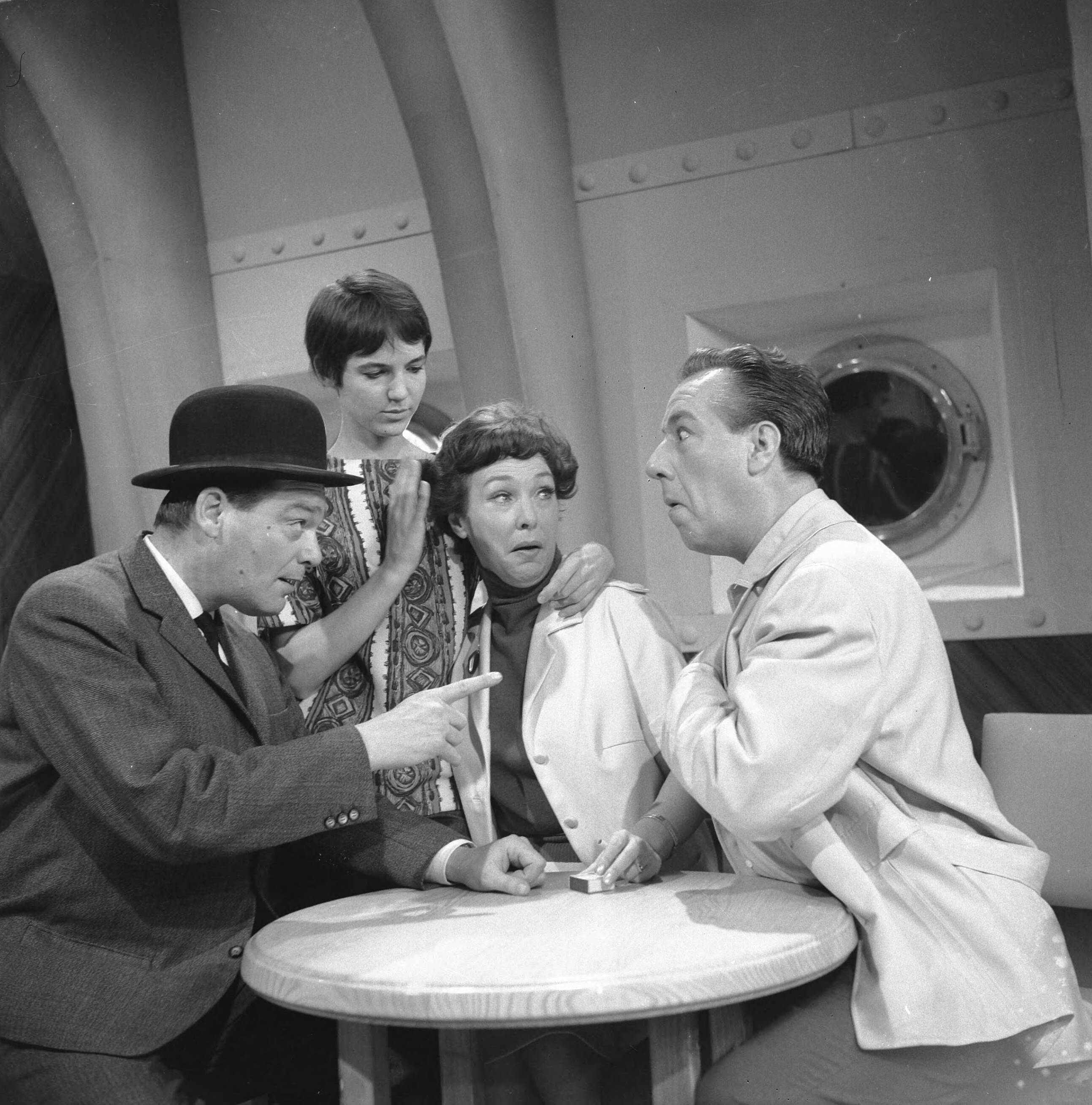 Fotocollectie Anefo — Opname televisiespel "Met 24 pk door Europa" (uitzending niet doorgegaan). Vlnr. Jan Blaaser, Simone Rooskens, Teddy Schaank en Ko van DijkNegatieven zijn een jaar later, op 31-3-1964, geregistreerd in fotoadministratie Anefo! Deze aflevering is wél uitgezonden, als eerste op 20-10-1963. Op 22-11-1963 schrijft Trouw: Er komen geen afleveringen meer van de televisiestrip "Met 24 P.K. door Europa" met Ko van Dijk, Teddy Schaank en Simone Rooskens. De AVRO heeft besloten de serie te staken. Reden: de strip kon ook na bewerking van het oorspronkelijke script niet aan de gestelde eisen voldoen. Karel Prior, hoofd amusementsprogramma's van de AVRO zei van deze door het echtpaar Mazure geschreven strip, dat ze „te filmisch" waren geschreven, waardoor men er in de televisiestudio's niet goed mee uit de voeten kon. Ellen en Georges Mazure, die zes afleveringen van hun strip aan de AVRO verkochten, liggen al een poosje overhoop met de AVRO in verband met de televisie-uitzen