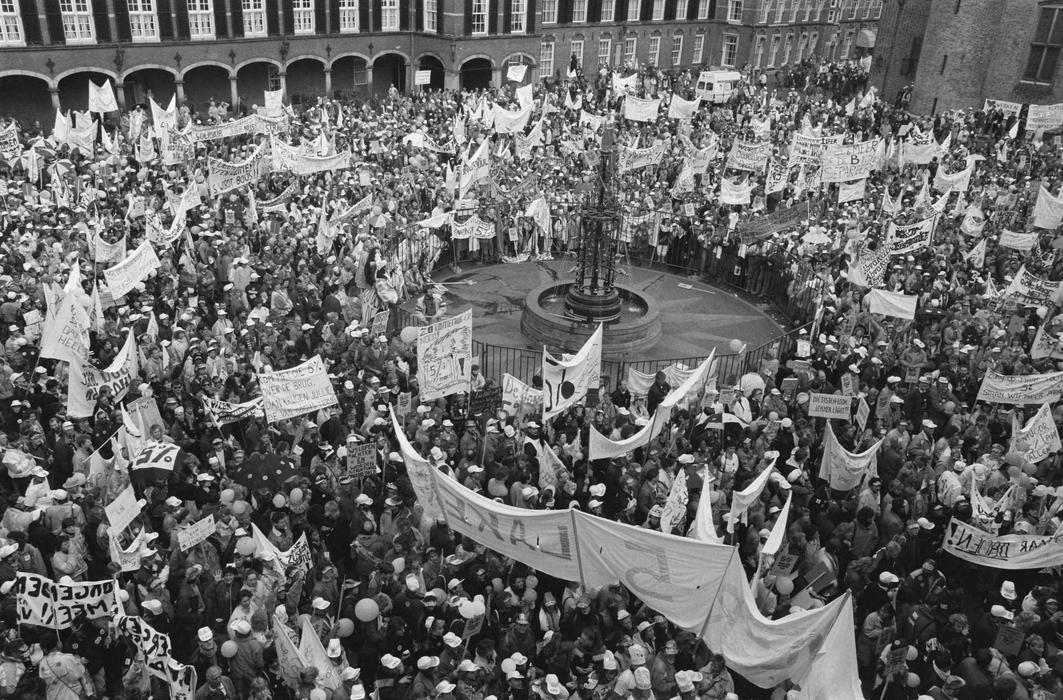 Demonstratie meer dan 50.000 verpleegkundigen in Den Haag — Demonstranten met spandoeken op het Binnenhof — Foto: Croes, Rob C. / Anefo. Licentie: Set B: Rechtenvrij / Publiek Domein. Bron: Nationaal Archief. http://hdl.handle.net/10648/ad724678-d0b4-102d-bcf8-003048976d84