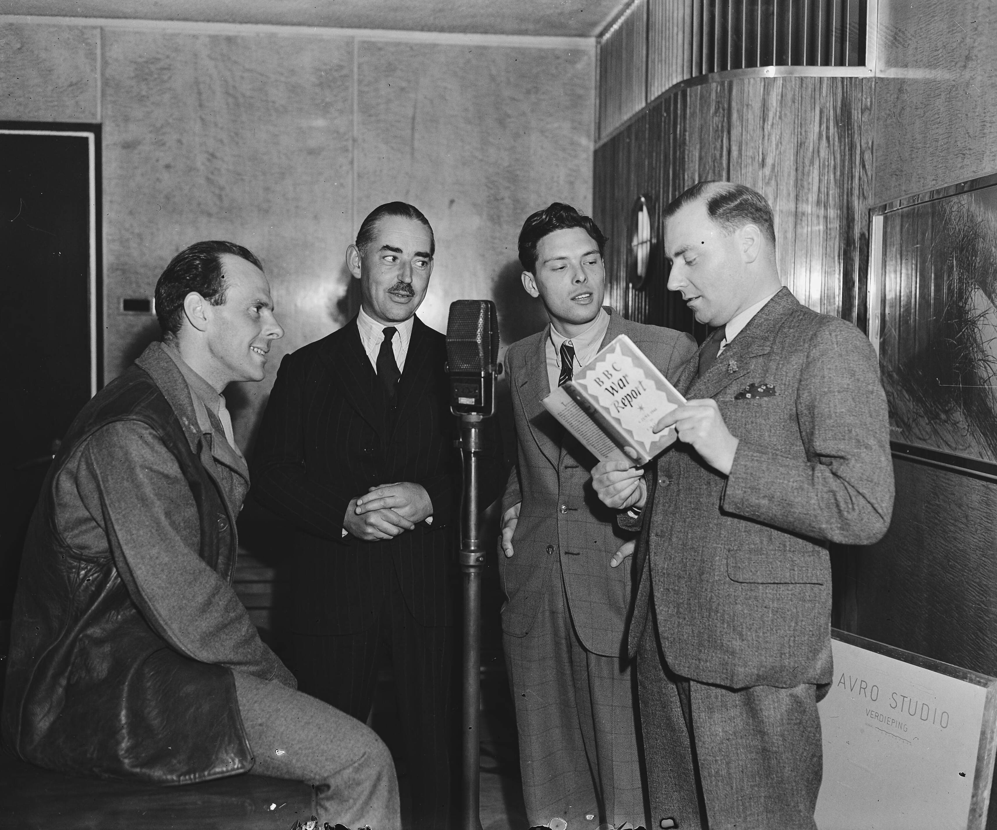 Fotocollectie Anefo — Delegatie van de BBC bezoekt Nederland. BBC-omroepers in Hilversum. Vlnr ? , John Snagge, ?, Frank Gillard — Foto: Raucamp, Koos / Anefo. Licentie: Set B: Rechtenvrij / Publiek Domein. Bron: Nationaal Archief. http://hdl.handle.net/10648/a89cdd98-d0b4-102d-bcf8-003048976d84