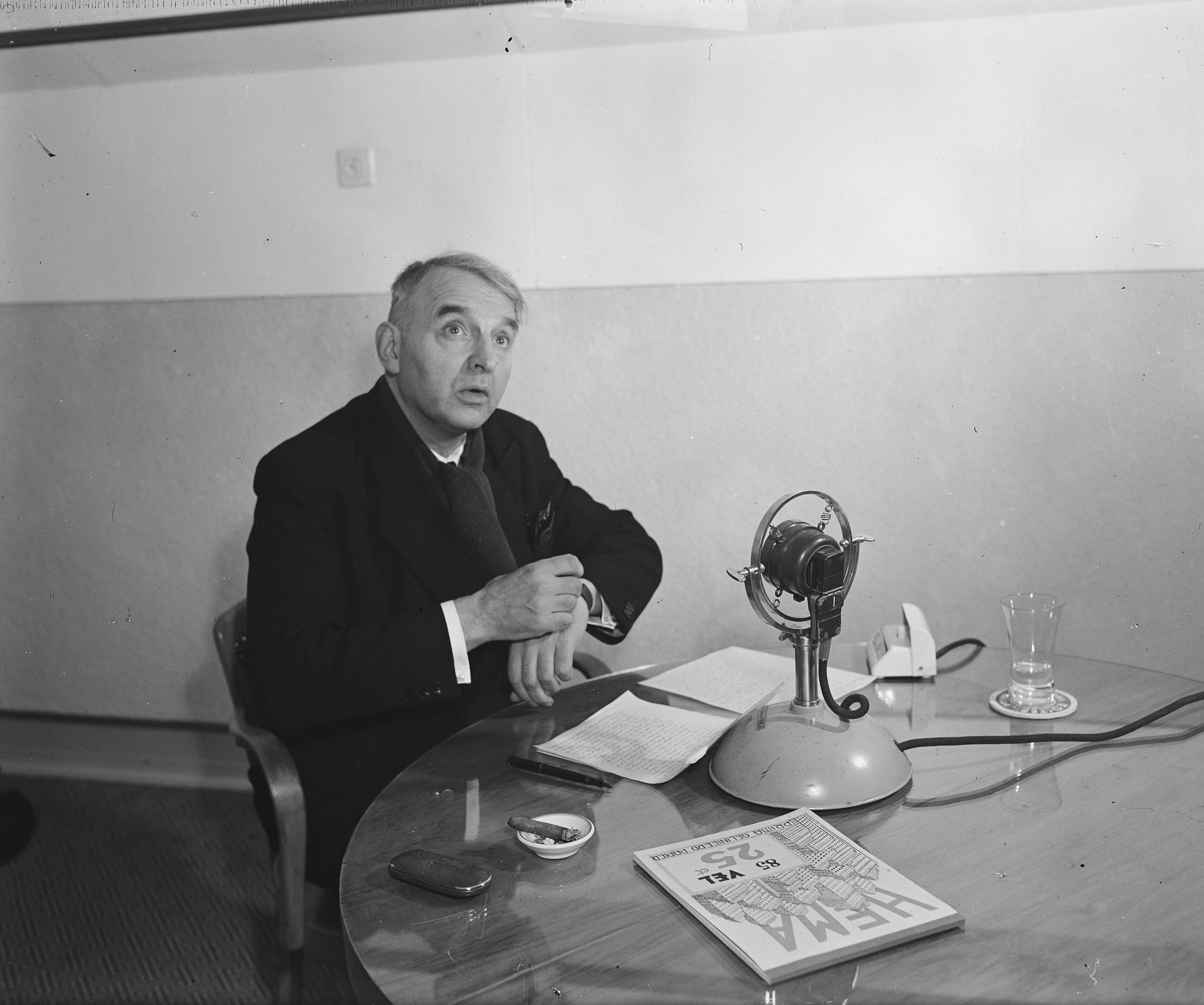 Pater Henri de Greeve houdt zijn radiotoespraak — In de studio van de KRO, voor de microfoon — Foto: Raucamp, Koos / Anefo. Licentie: Set B: Rechtenvrij / Publiek Domein. Bron: Nationaal Archief. http://hdl.handle.net/10648/a896eb36-d0b4-102d-bcf8-003048976d84