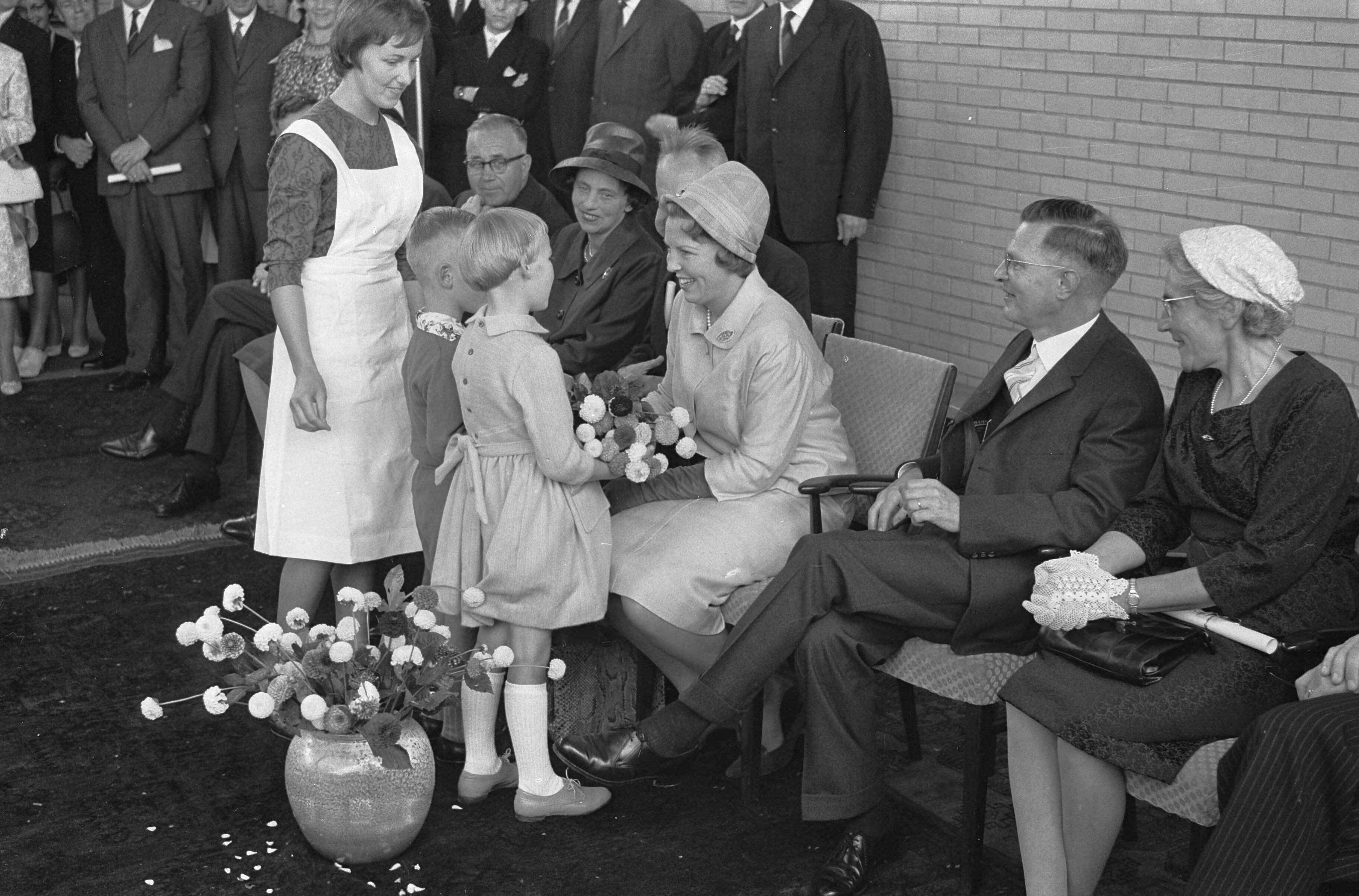 Fotocollectie Anefo — Prinses Beatrix opent Buitenschool in Leeuwarden. De prinses krijgt bloemen in de gymnastiekzaal. Rechts E.H. Hijmersma, voorzitter van de Buitenschool — Foto: Pot, Harry / Anefo. Licentie: Set B: Rechtenvrij / Publiek Domein. Bron: Nationaal Archief. http://hdl.handle.net/10648/a9e265ec-d0b4-102d-bcf8-003048976d84