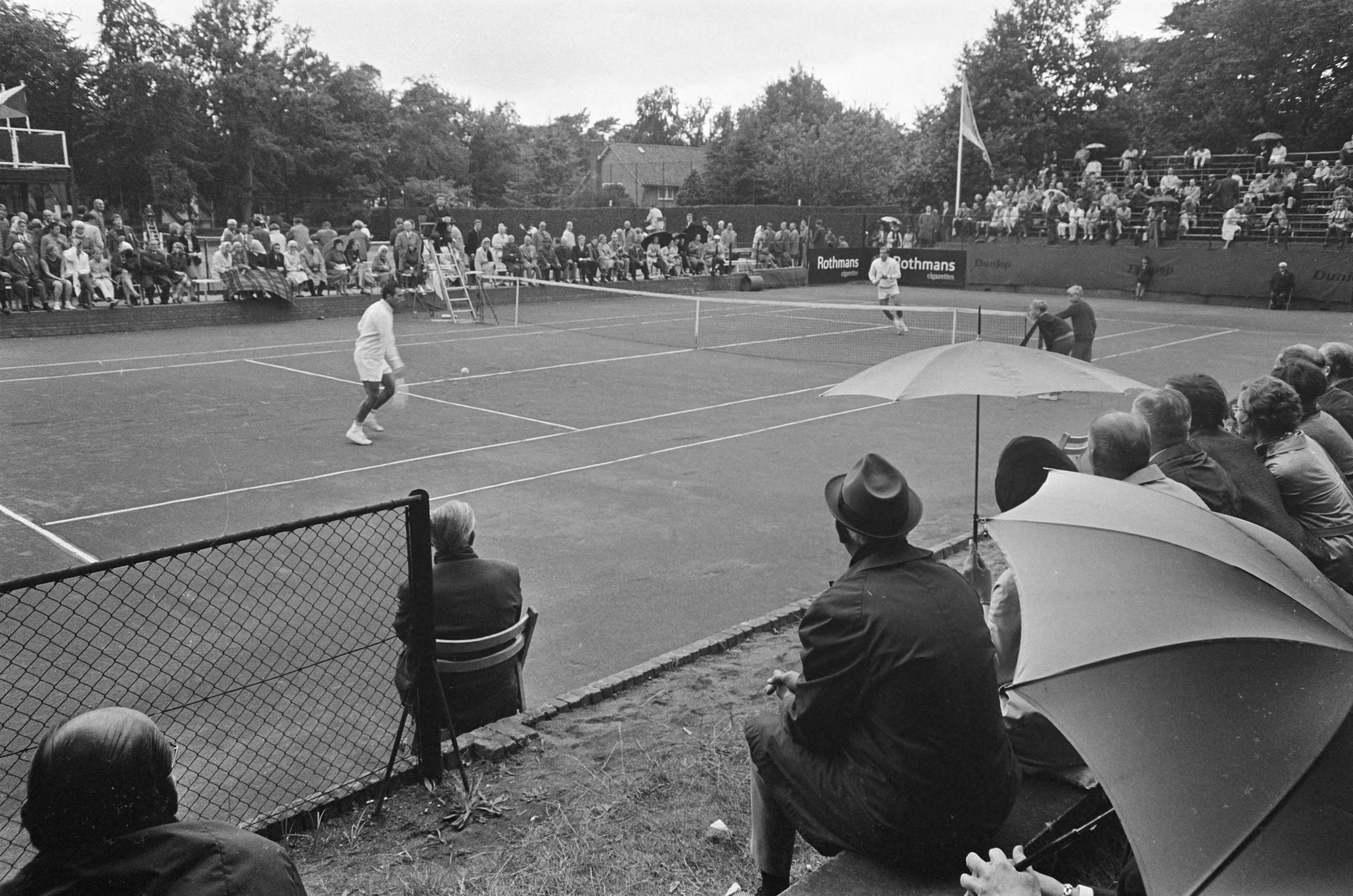 Fotocollectie Anefo — Internationaal tennistoernooi in Hilversum. Een partij tussen ? en ? (opdracht Vrije Volk) — Foto: Kroon, Ron / Anefo. Licentie: Set B: Rechtenvrij / Publiek Domein. Bron: Nationaal Archief. http://hdl.handle.net/10648/ab47f758-d0b4-102d-bcf8-003048976d84