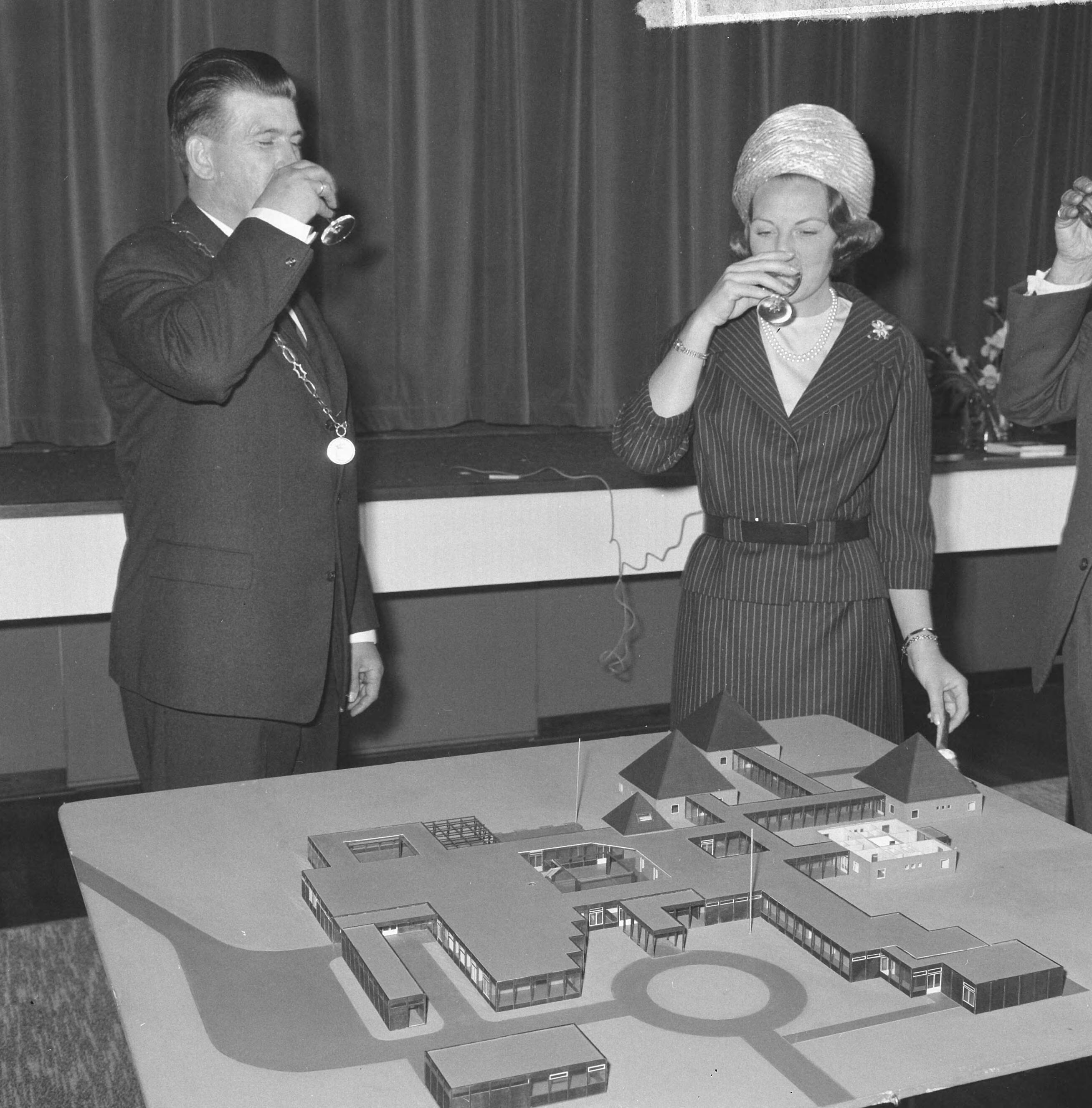 Fotocollectie Anefo — Prinses Beatrix was aanwezig bij de eerste steenlegging voor het jongerenontmoetingscentrum "Het Zilveren Schor" nabij Arnemuiden. Burgemeester A. Hack toost met prinses Beatrix. Voor hen de maquette van het gebouw, een ontwerp van architect Onno Greiner — Foto: Nijs, Jac. de / Anefo. Licentie: Set B: Rechtenvrij / Publiek Domein. Bron: Nationaal Archief. http://hdl.handle.net/10648/aaa1cab8-d0b4-102d-bcf8-003048976d84