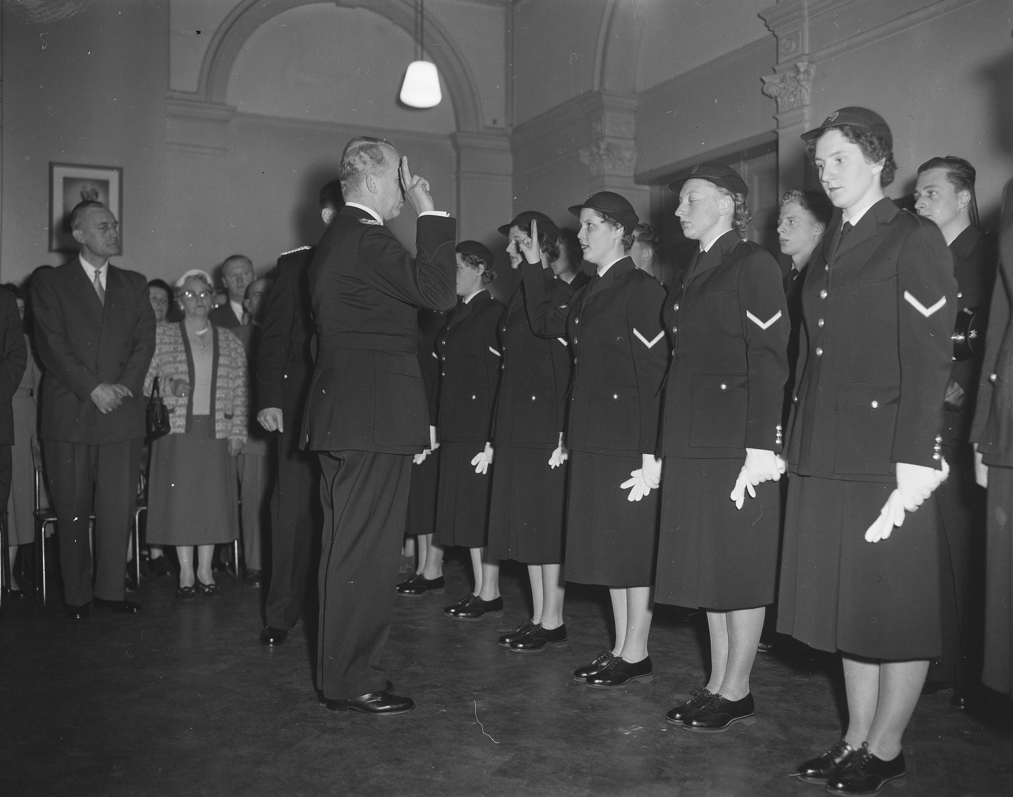 Fotocollectie Anefo — Beëdiging van eerste vrouwelijke politie-agenten van Den Haag door de hoofdcommissaris van politie — Foto: Bilsen, Joop van / Anefo. Licentie: Set B: Rechtenvrij / Publiek Domein. Bron: Nationaal Archief. http://hdl.handle.net/10648/a9553fe6-d0b4-102d-bcf8-003048976d84
