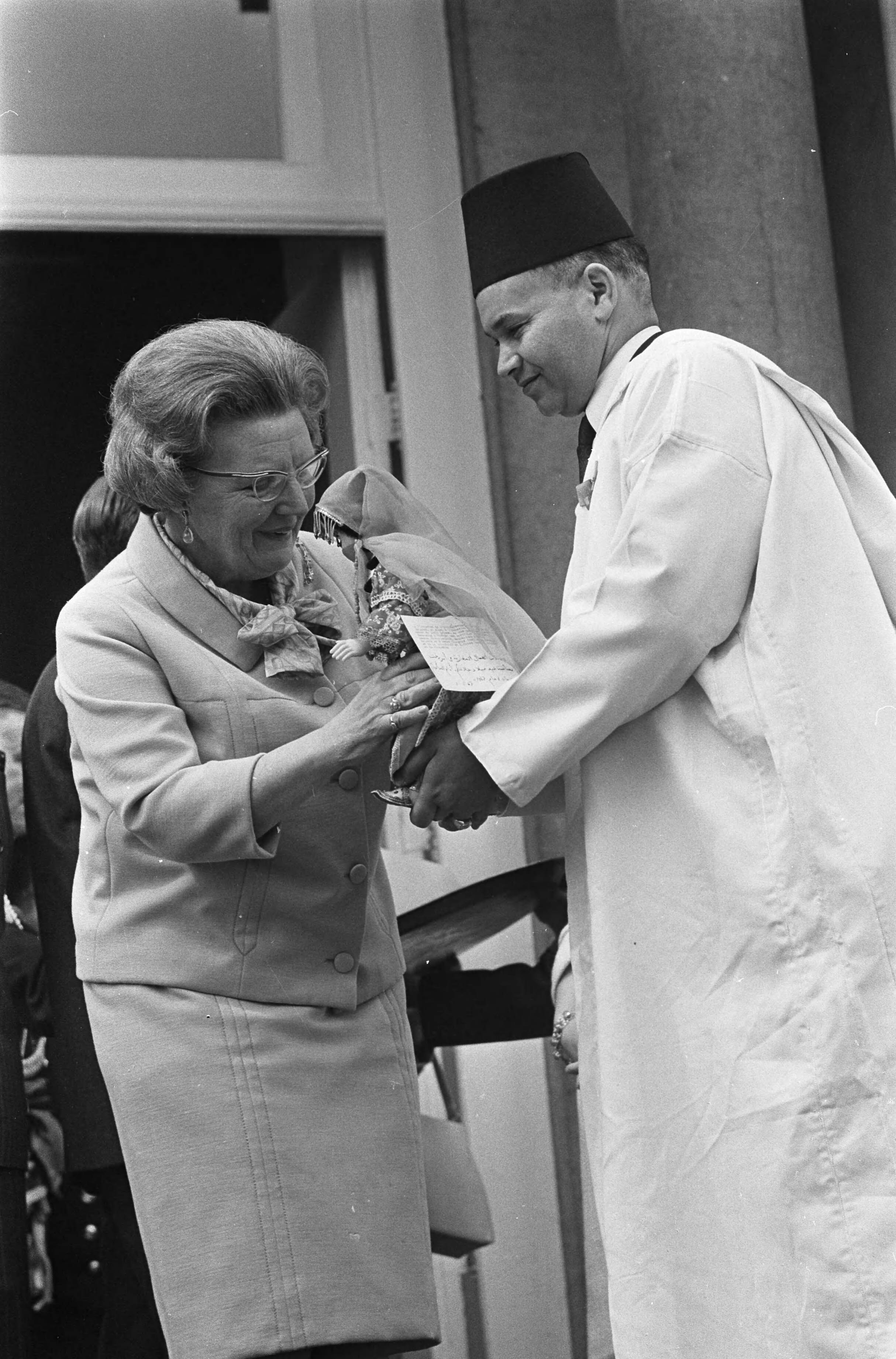 Fotocollectie Anefo — Koningin Juliana 58 jaar, defilé op Paleis Soestdijk, namens de Marokkaanse gastarbeiders werd Hare Majesteit een geschenk aangeboden door de heer Mouhmi — Foto: Nijs, Jac. de / Anefo. Licentie: Set B: Rechtenvrij / Publiek Domein. Bron: Nationaal Archief. http://hdl.handle.net/10648/ab1786b8-d0b4-102d-bcf8-003048976d84