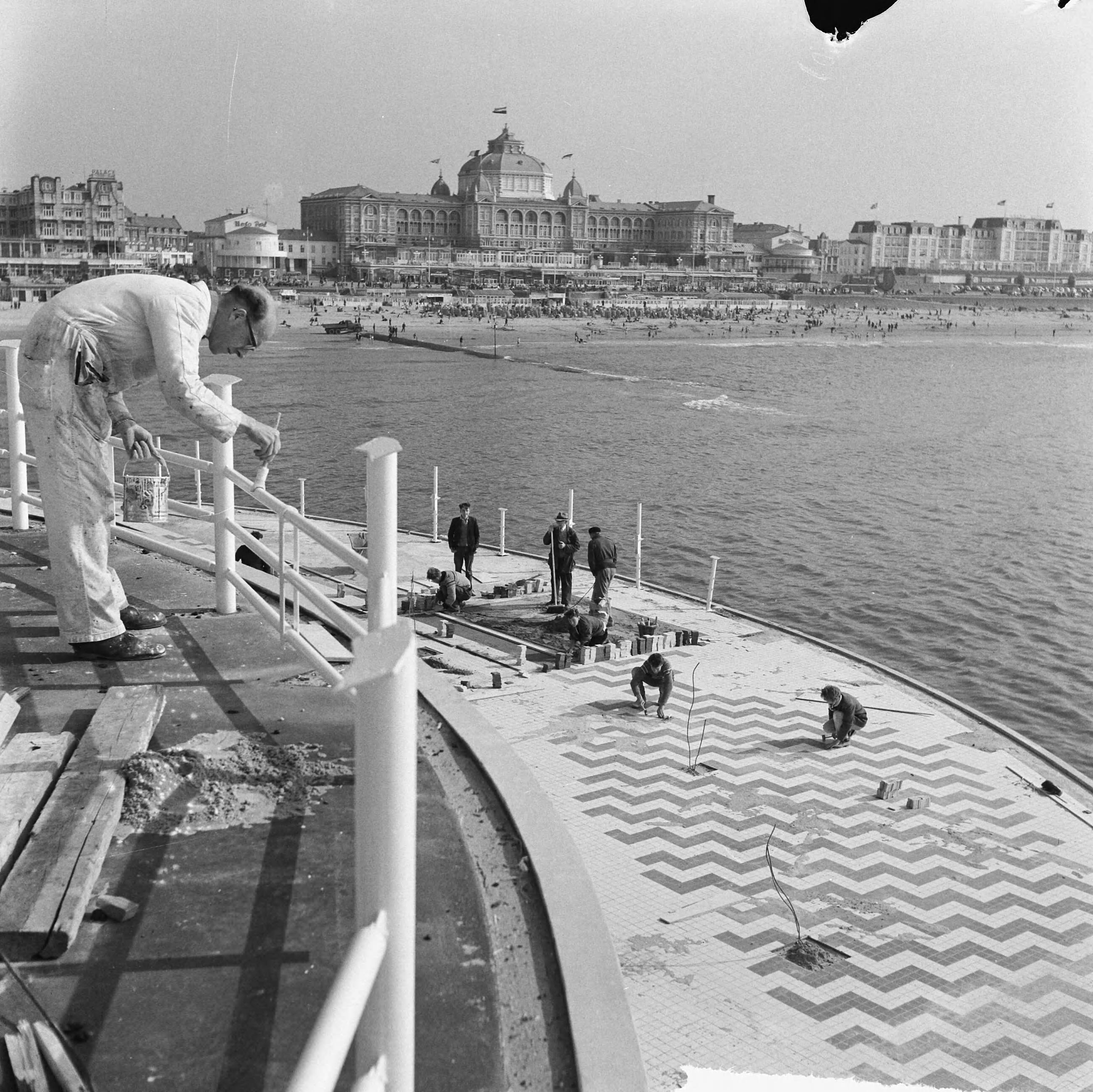 Fotocollectie Anefo — Werkzaamheden Pier te Scheveningen. Schilderen van restaurant en wegen betegelen — Foto: Nijs, Jac. de / Anefo. Licentie: Set B: Rechtenvrij / Publiek Domein. Bron: Nationaal Archief. http://hdl.handle.net/10648/a9d0f85c-d0b4-102d-bcf8-003048976d84