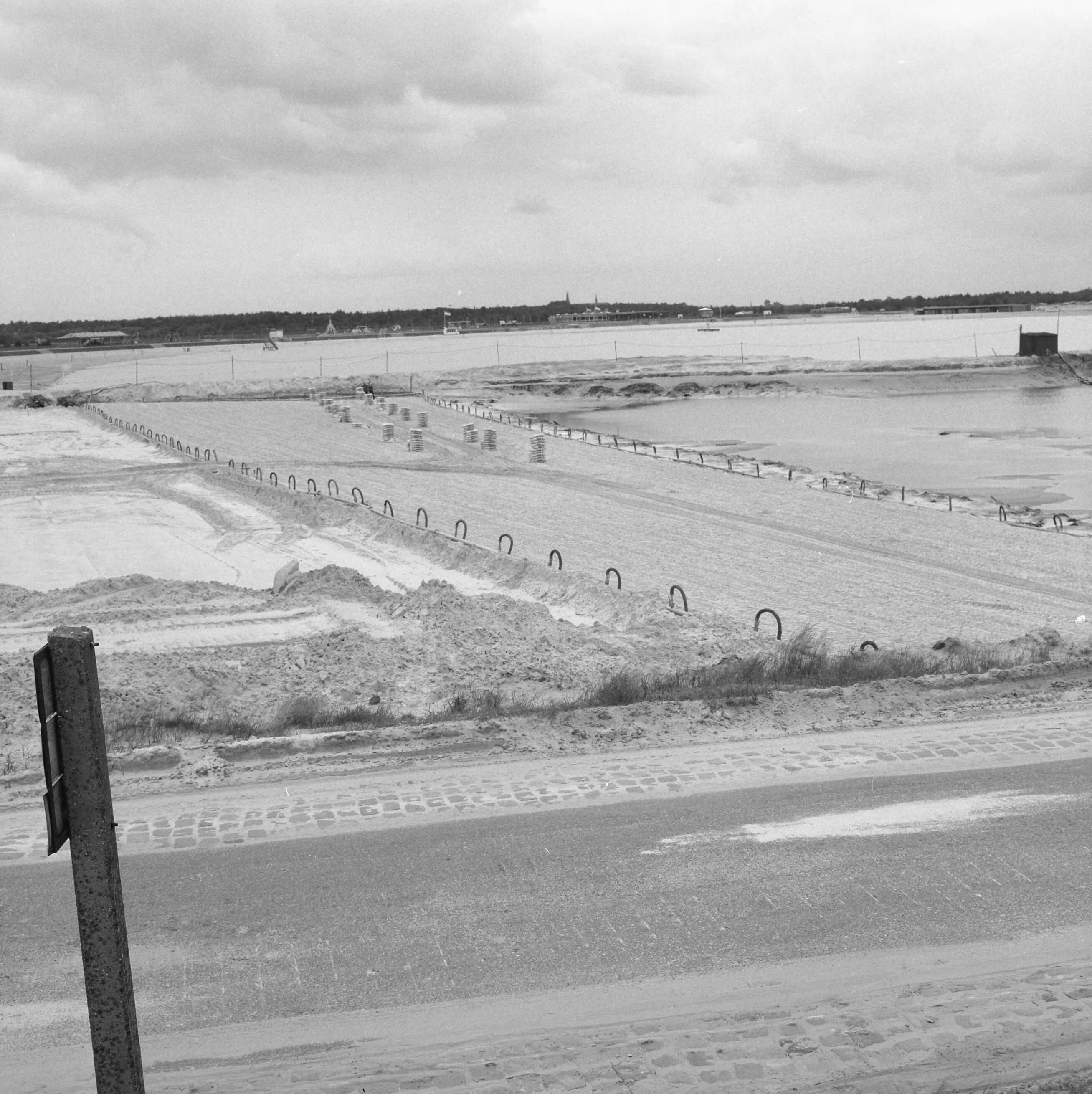 Fotocollectie Nederlandse Heidemaatschappij — Strandbad "Beekse Bergen". Overzicht van het werkterrein waar de eerst vracht cement is aangevoerd — Foto: Wüllschleger, [...] / Heidemij. Licentie: Set B: Rechtenvrij / Publiek Domein. Bron: Nationaal Archief. http://hdl.handle.net/10648/ae851b76-d0b4-102d-bcf8-003048976d84